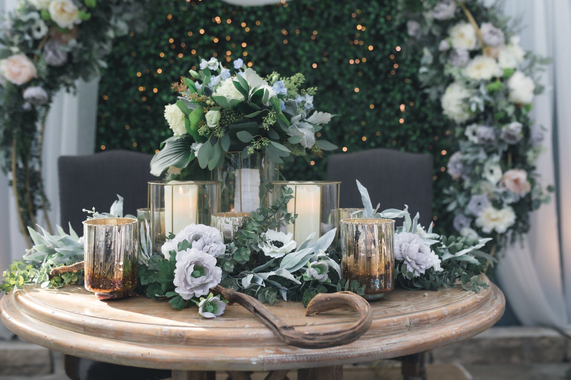 A wooden table with flowers and candles on it.