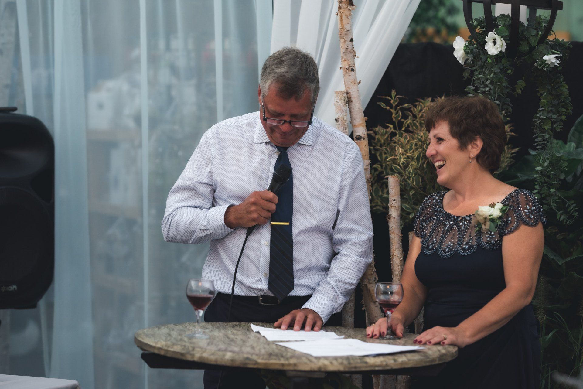 A man and a woman are sitting at a table with a microphone.