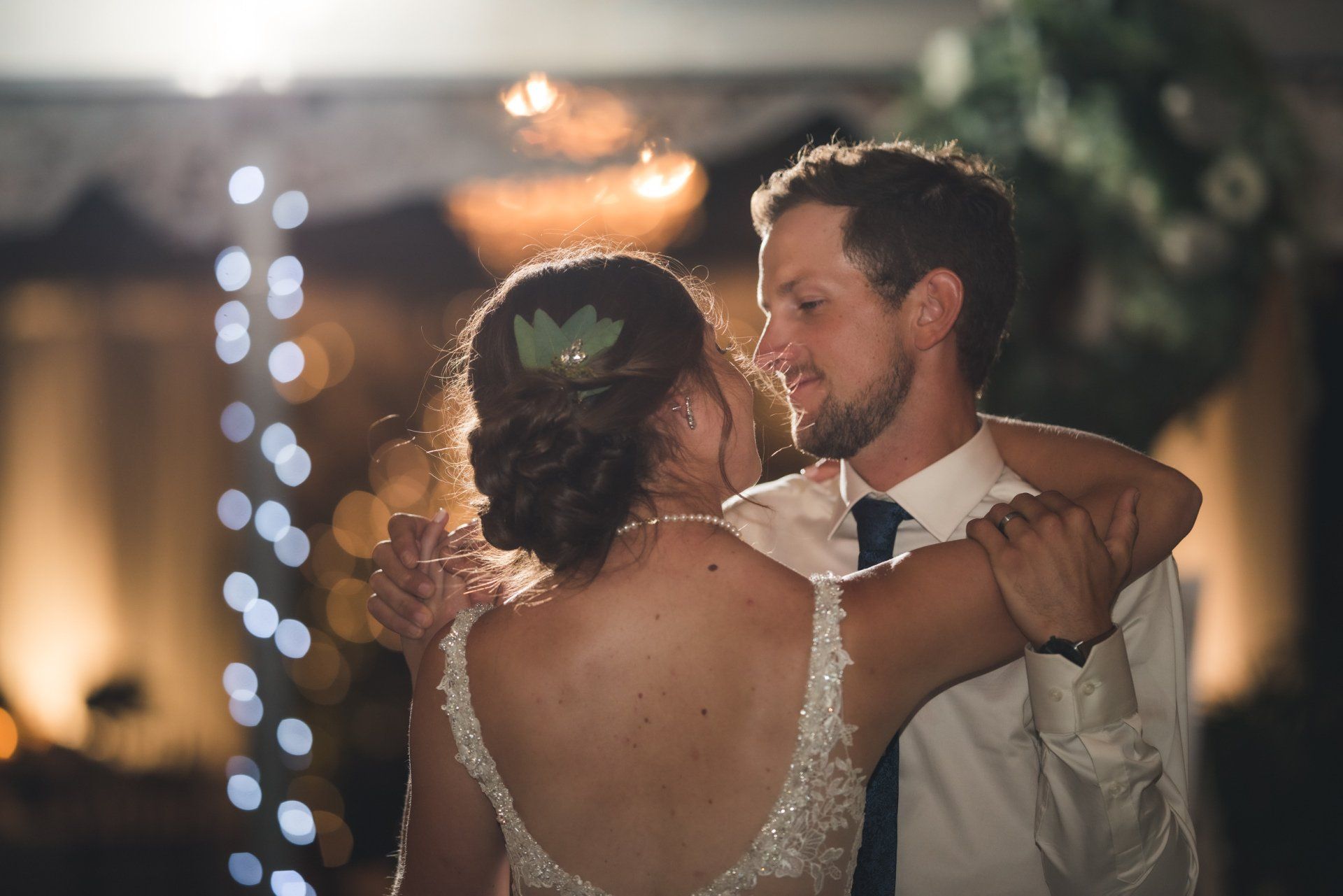 A bride and groom are dancing together at their wedding reception.