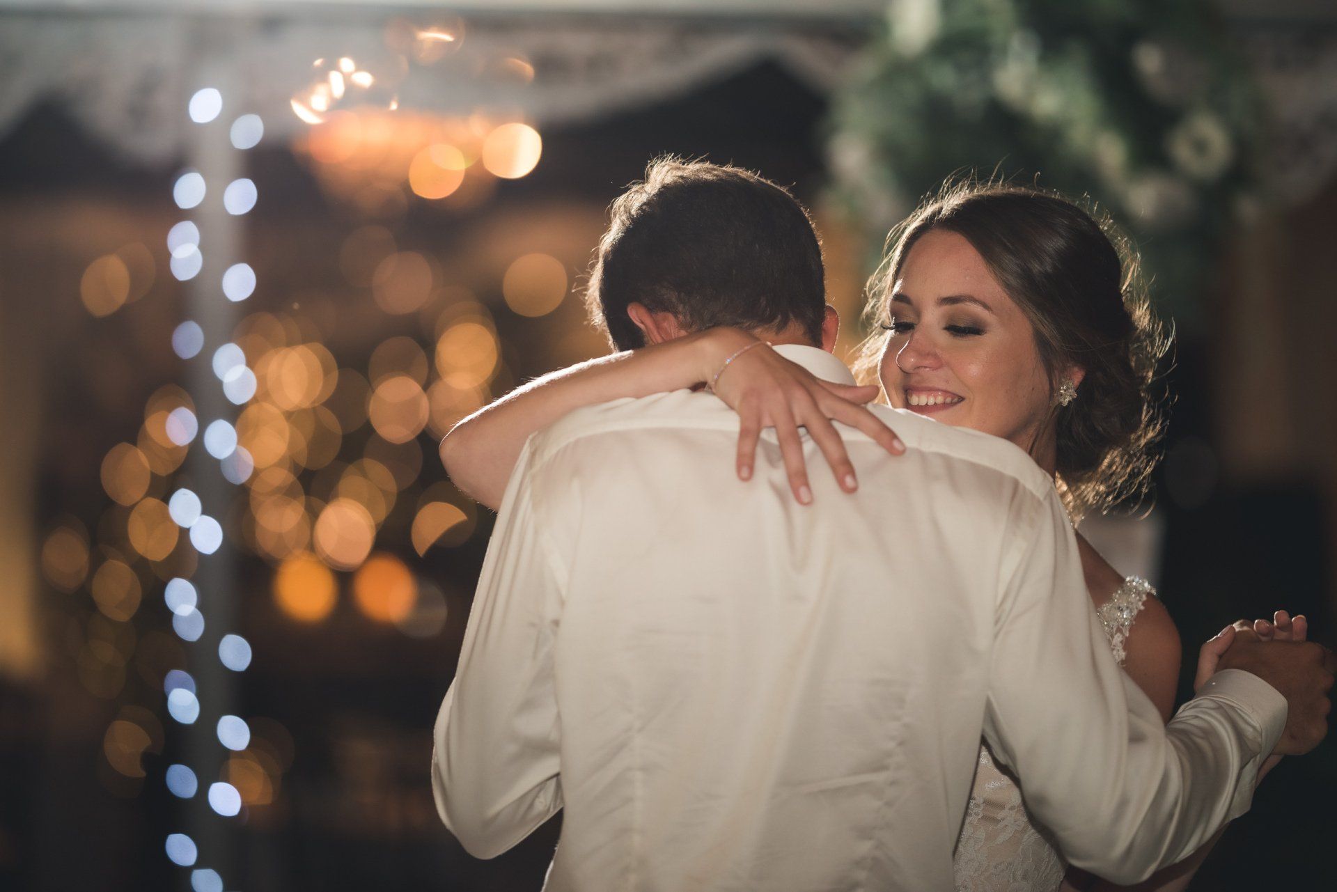 A bride and groom are dancing together at their wedding reception.