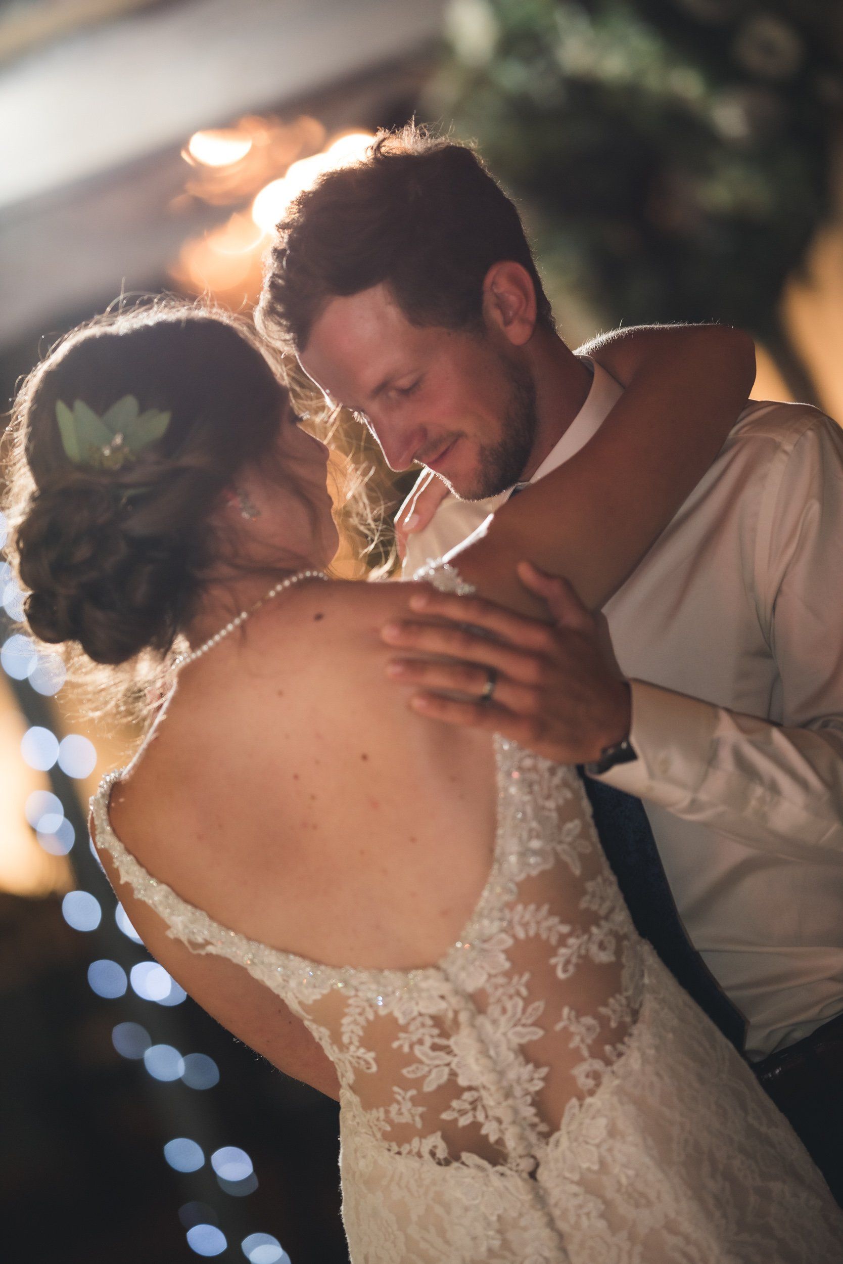 A bride and groom are dancing together at their wedding reception.