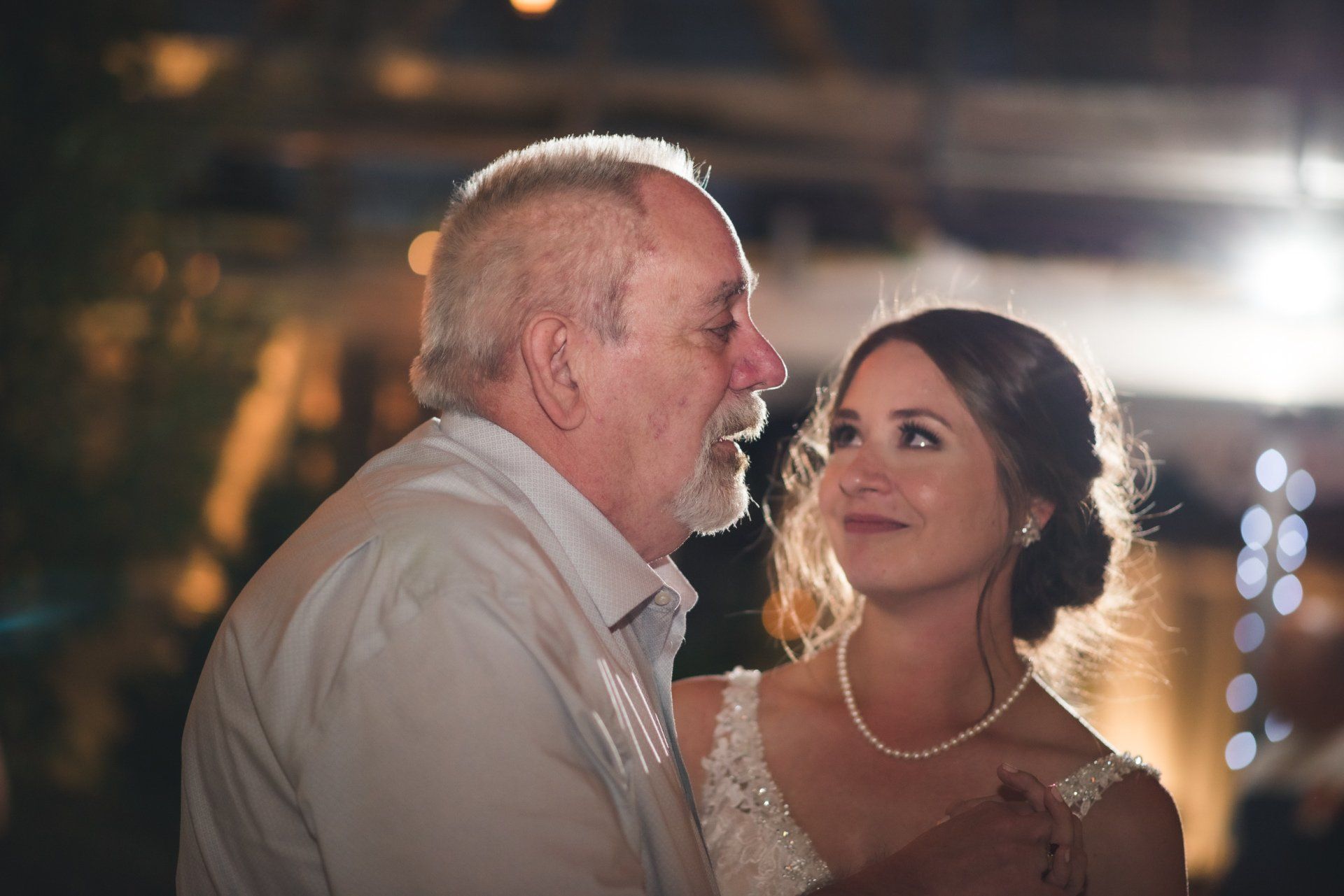 A man and a woman are dancing together at a wedding reception.