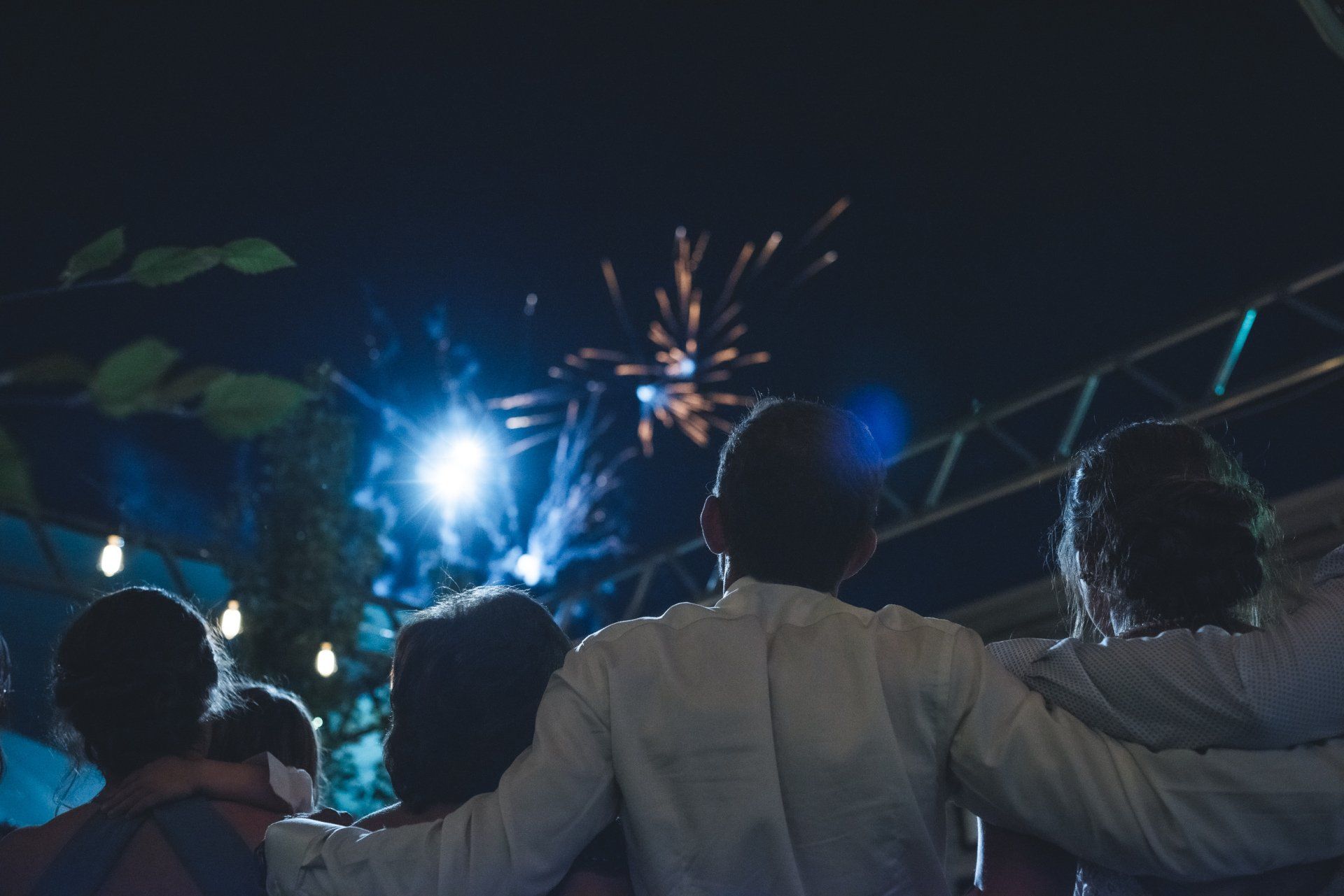 A group of people are watching fireworks in the night sky.
