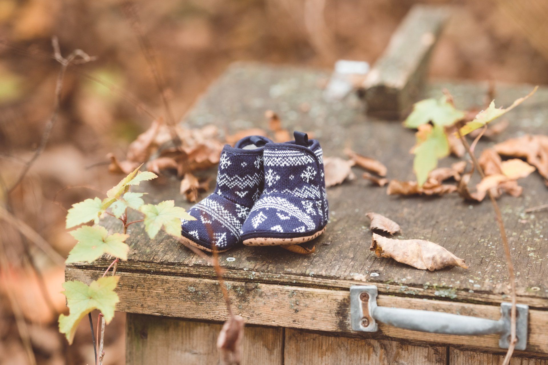 A pair of baby shoes sitting on top of a wooden box.