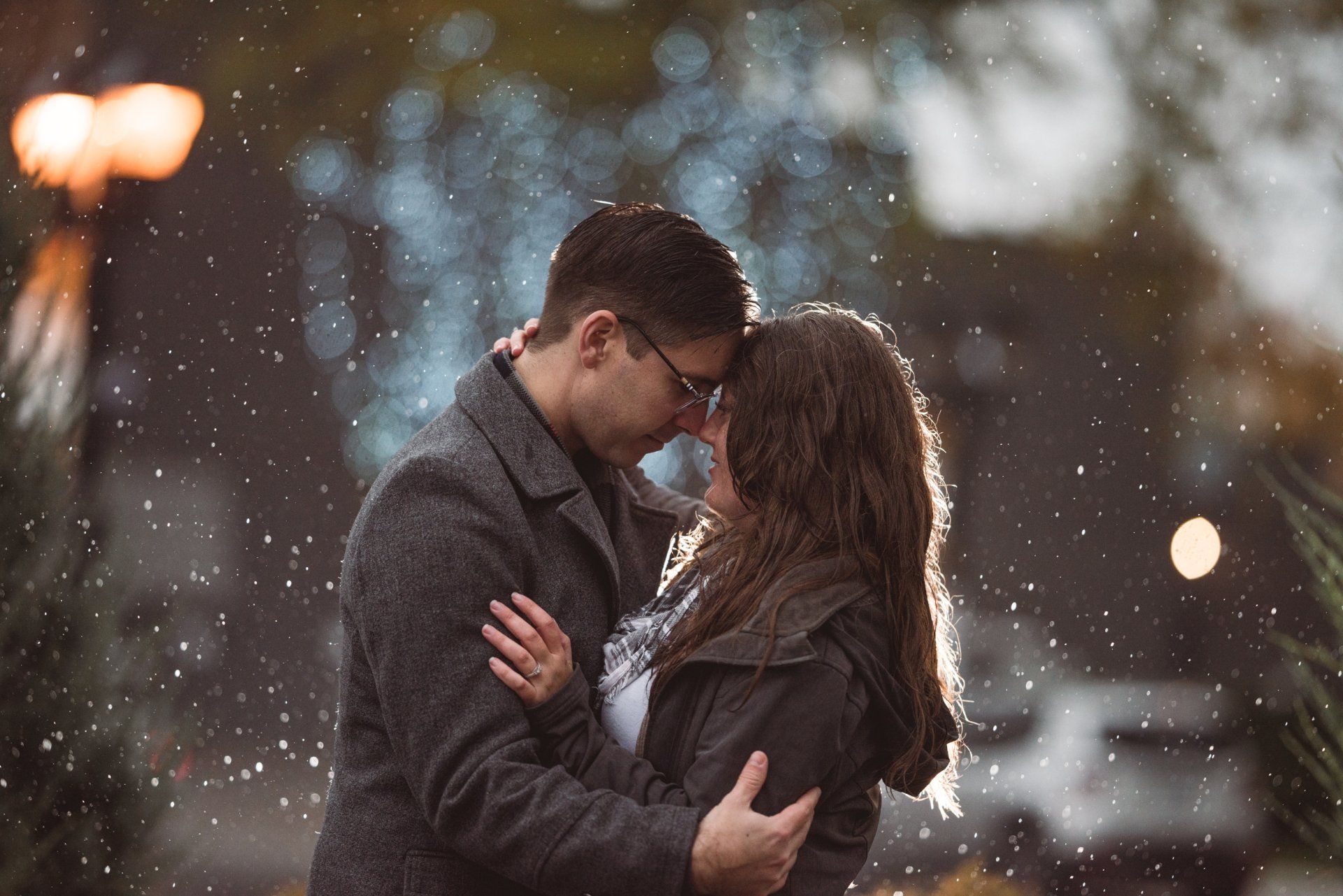 A man and a woman are kissing in the snow.