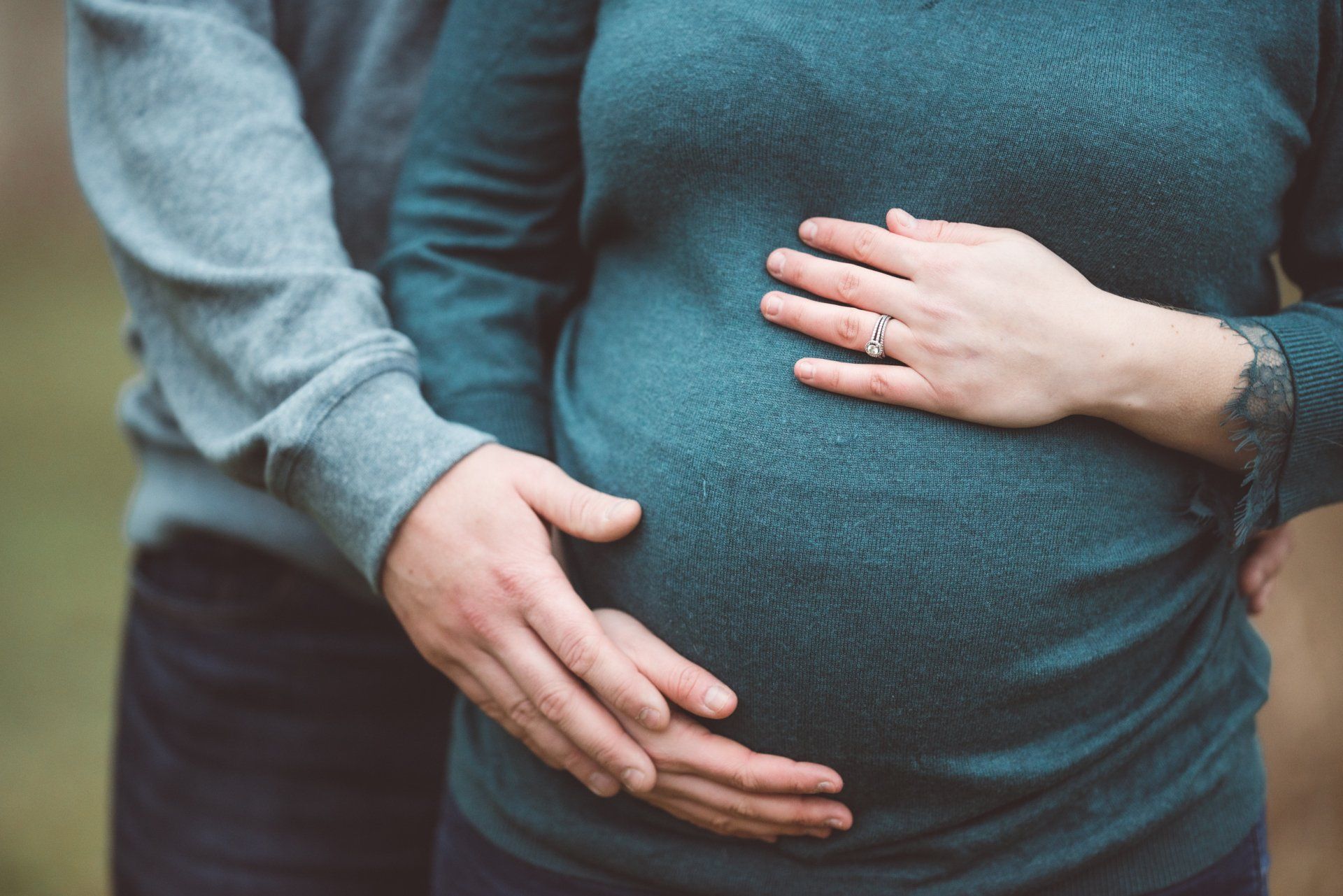 A man is hugging a pregnant woman 's belly.