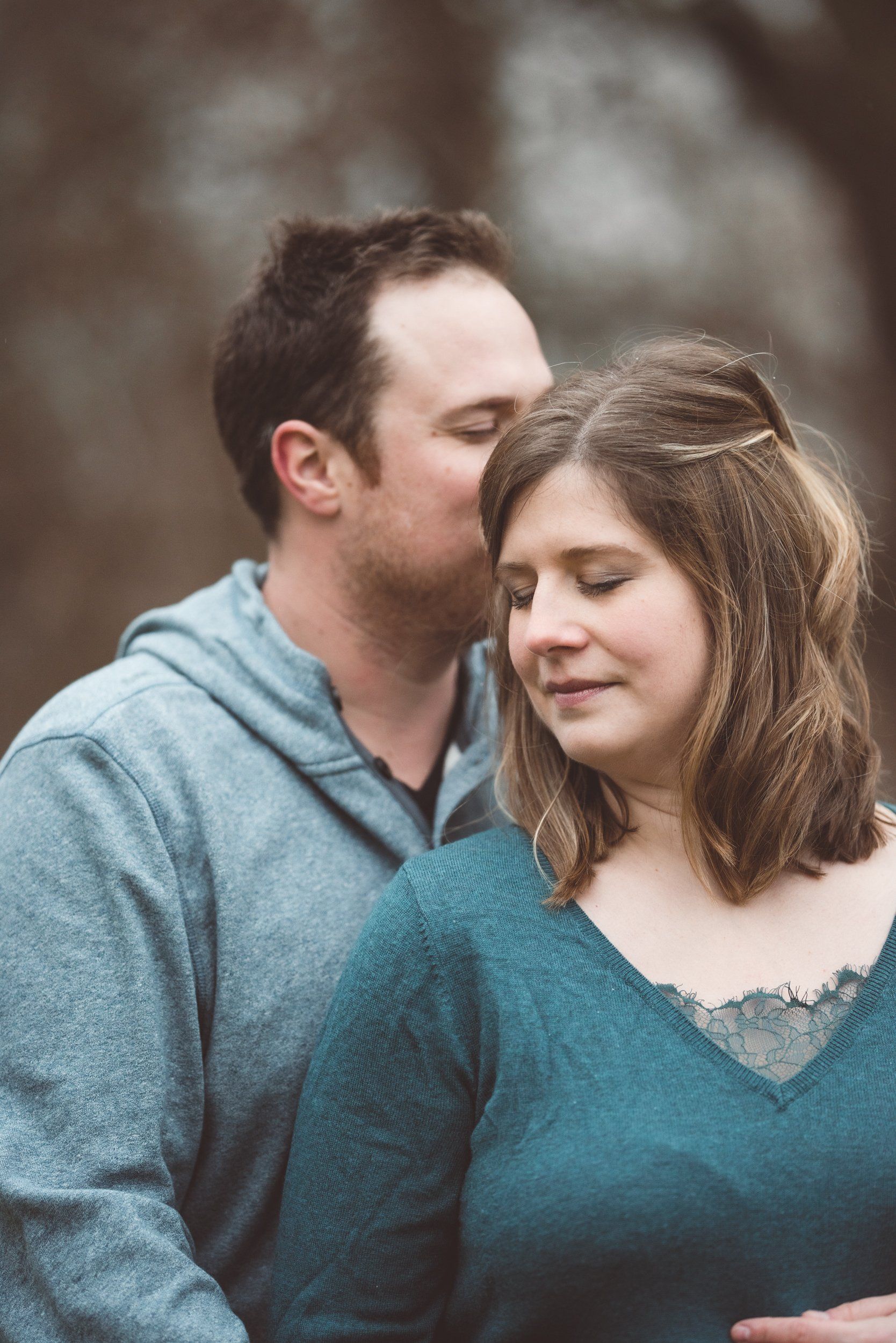 A man is kissing a woman on the forehead.