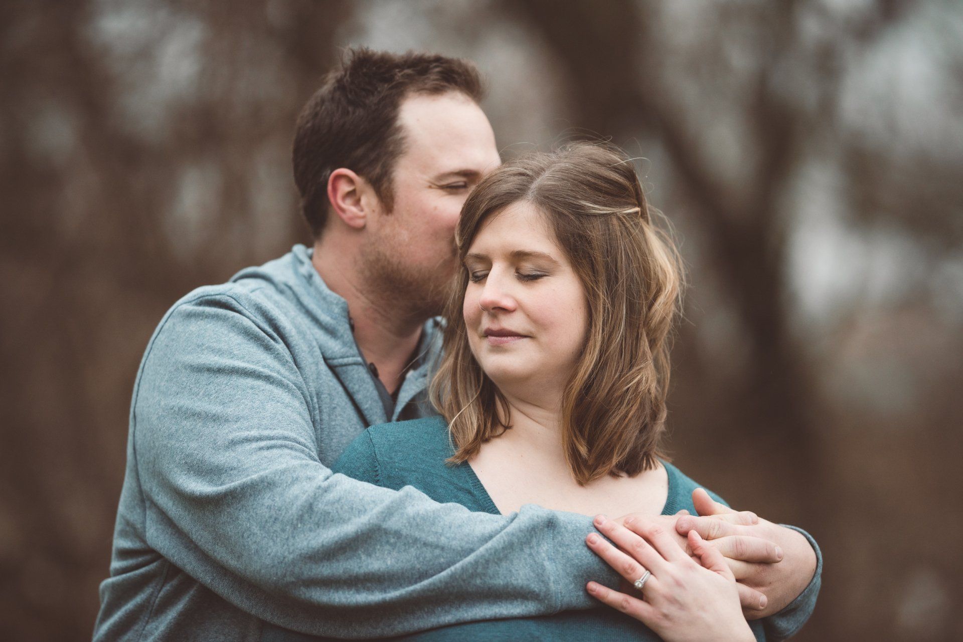 A man is kissing a woman on the forehead.