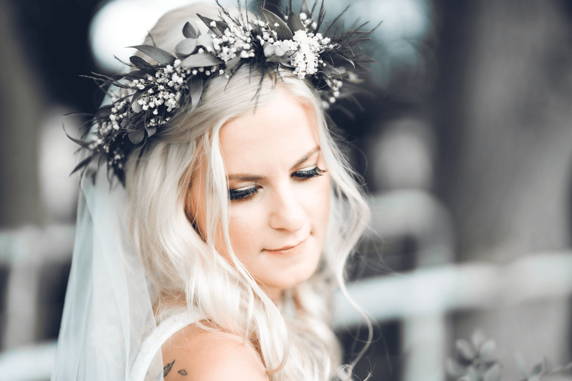 A bride wearing a veil and a flower crown on her head.