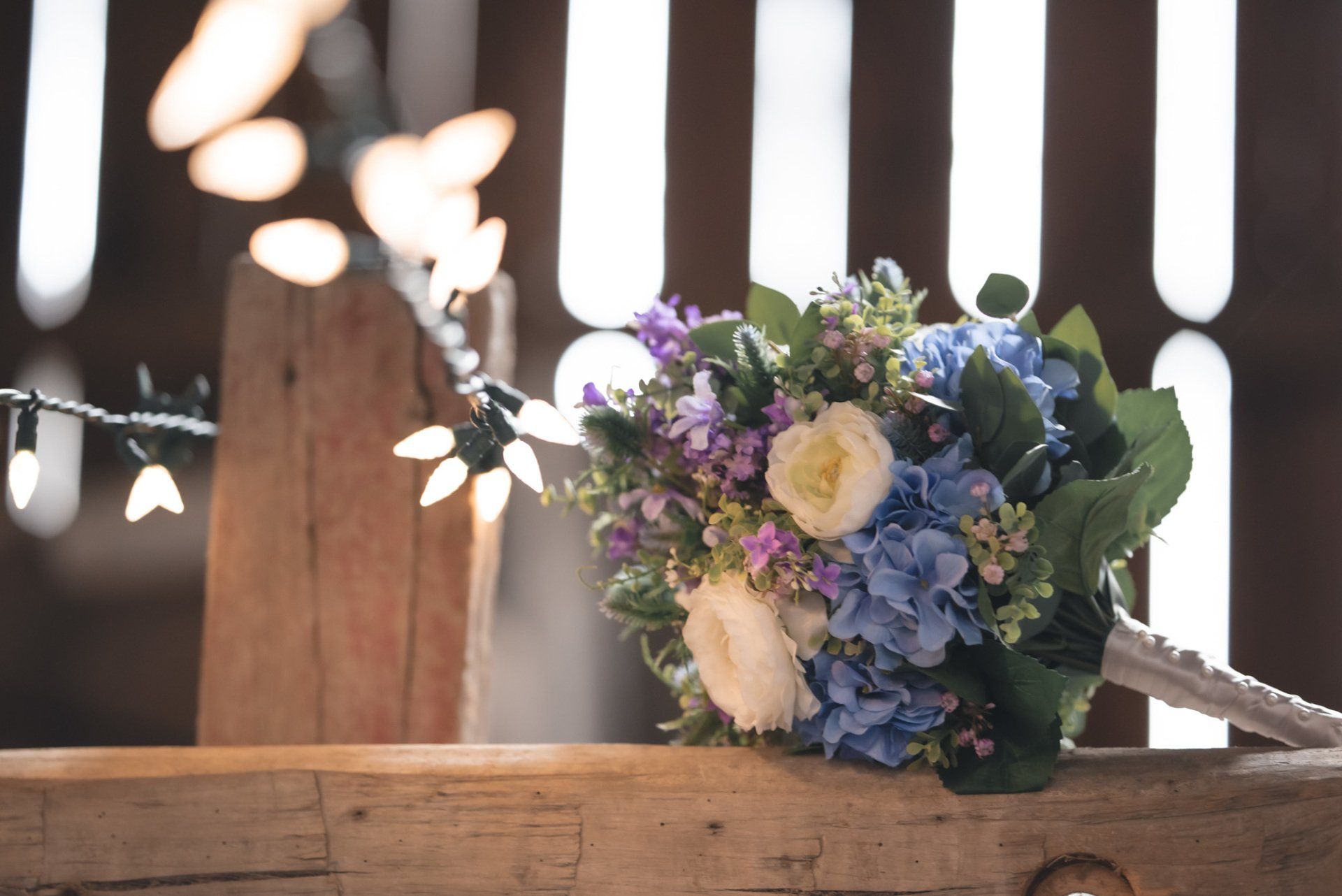 A bouquet of flowers is sitting on a wooden railing.