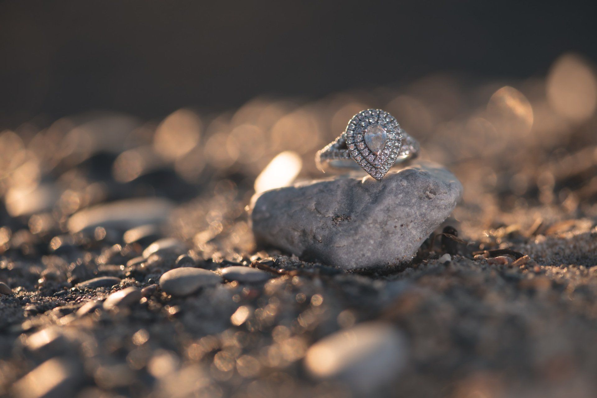 A diamond ring is sitting on top of a rock.