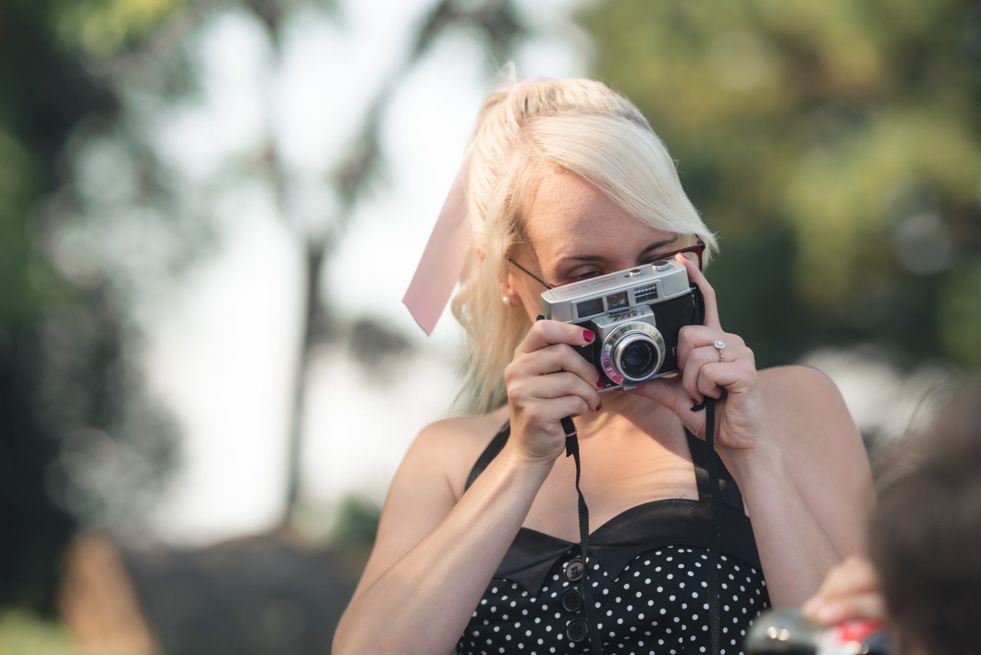 A woman is taking a picture with an old camera.