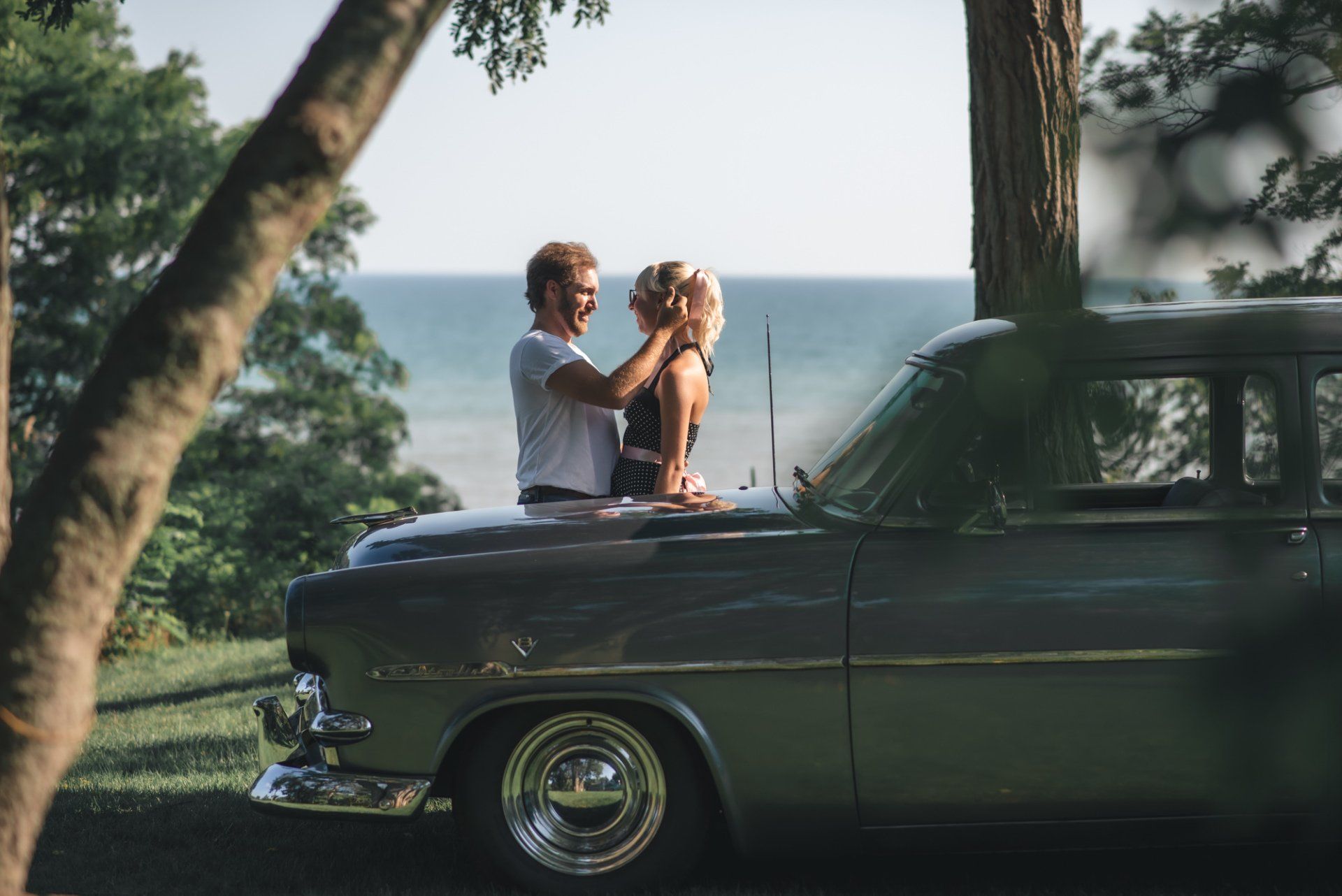 A man is putting a woman 's hair in a car.