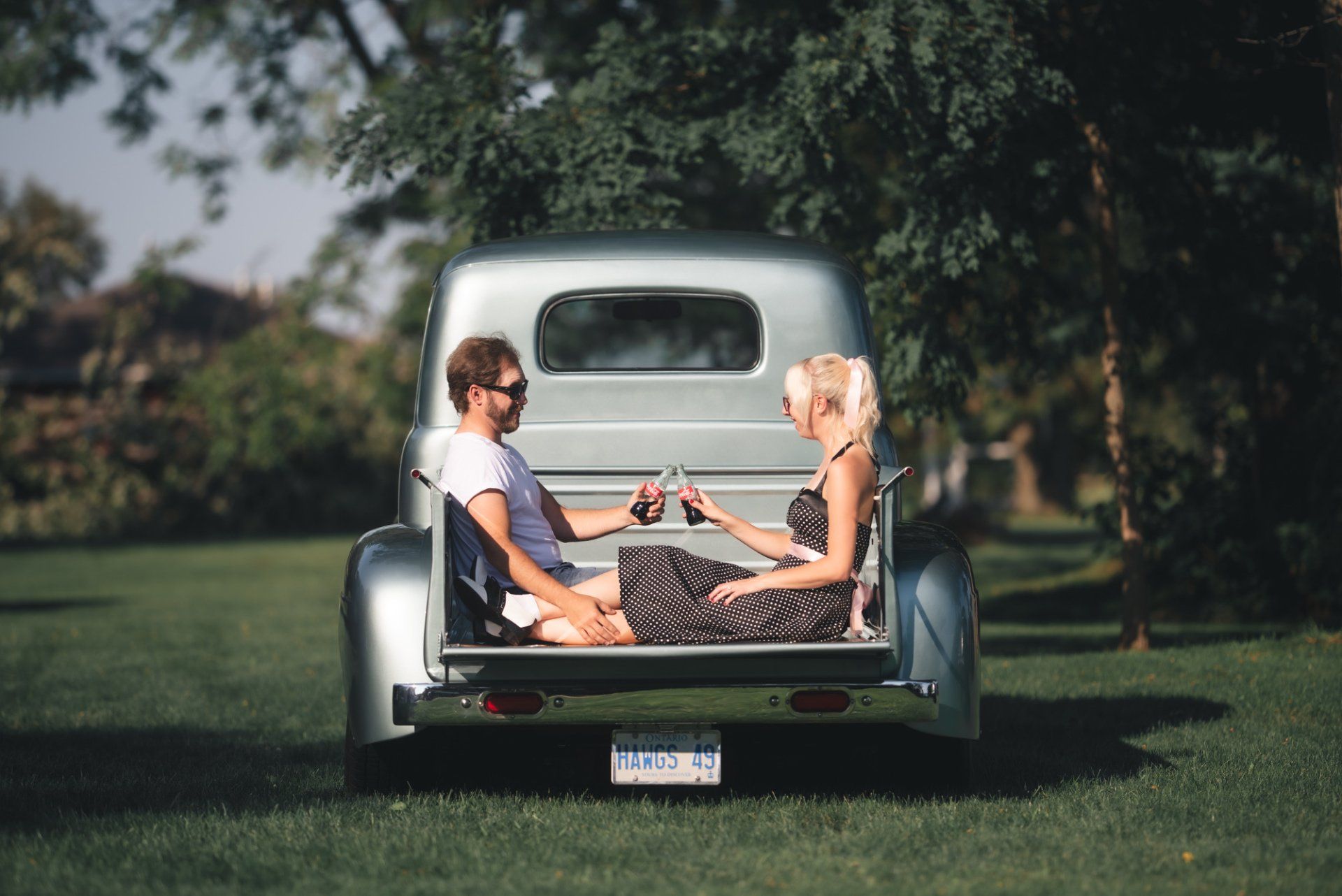 A man and a woman are sitting in the back of a truck.