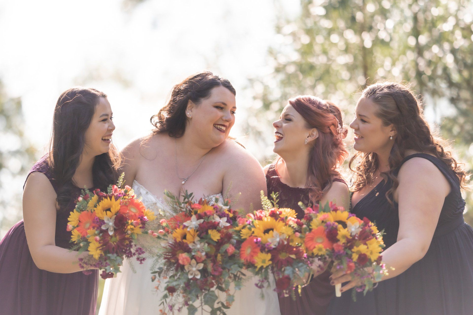A bride and her bridesmaids are posing for a picture while holding bouquets of flowers.
