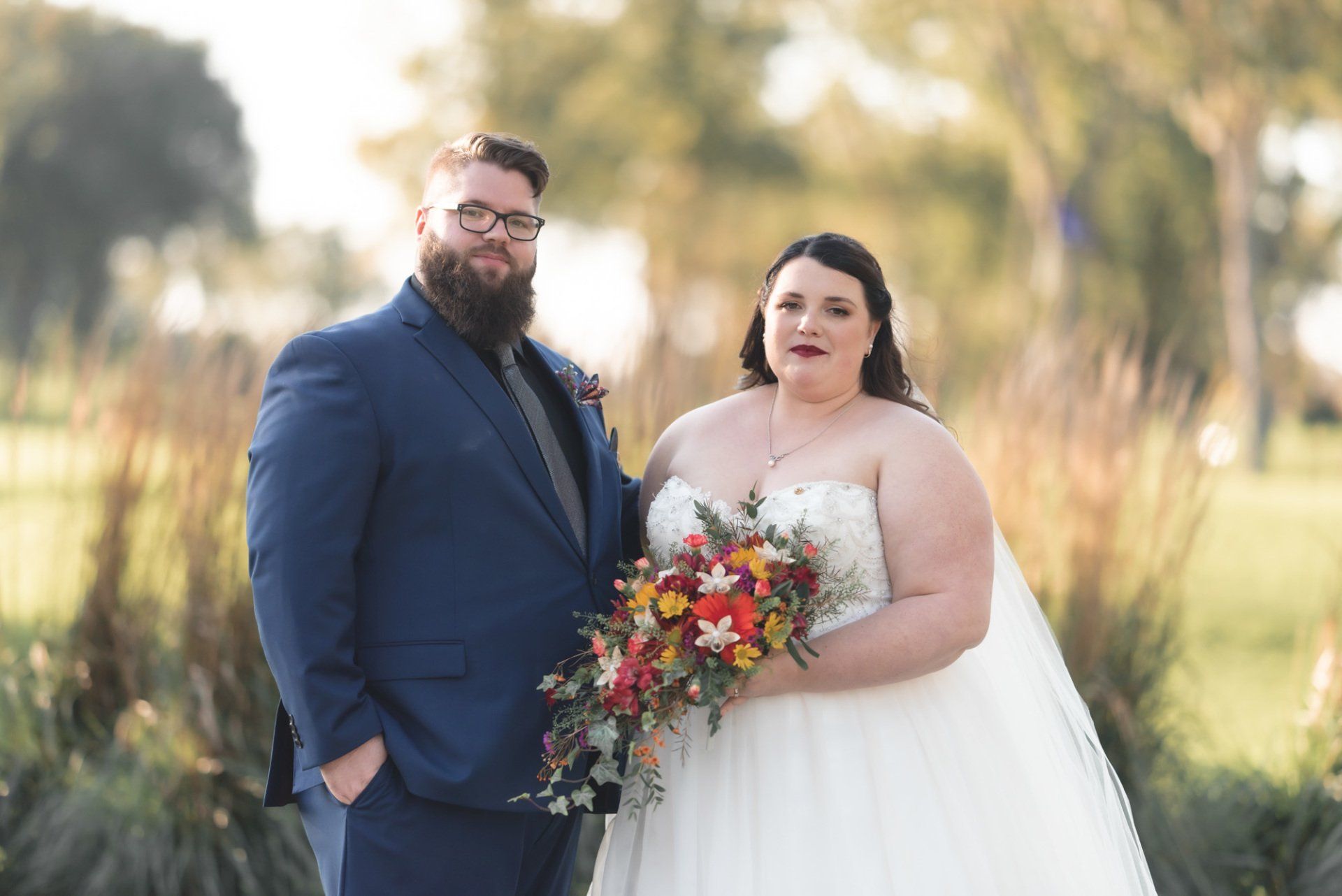 A bride and groom are posing for a picture on their wedding day.