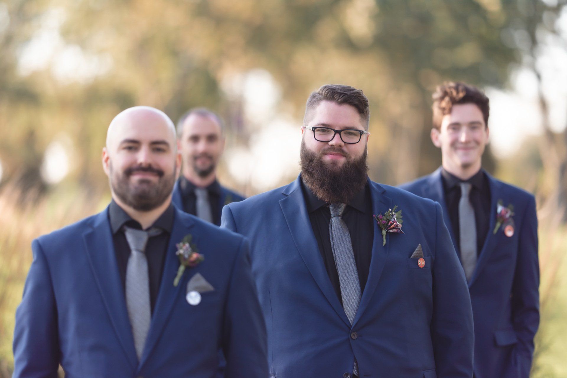 A groom and his groomsmen are walking down the aisle at a wedding.