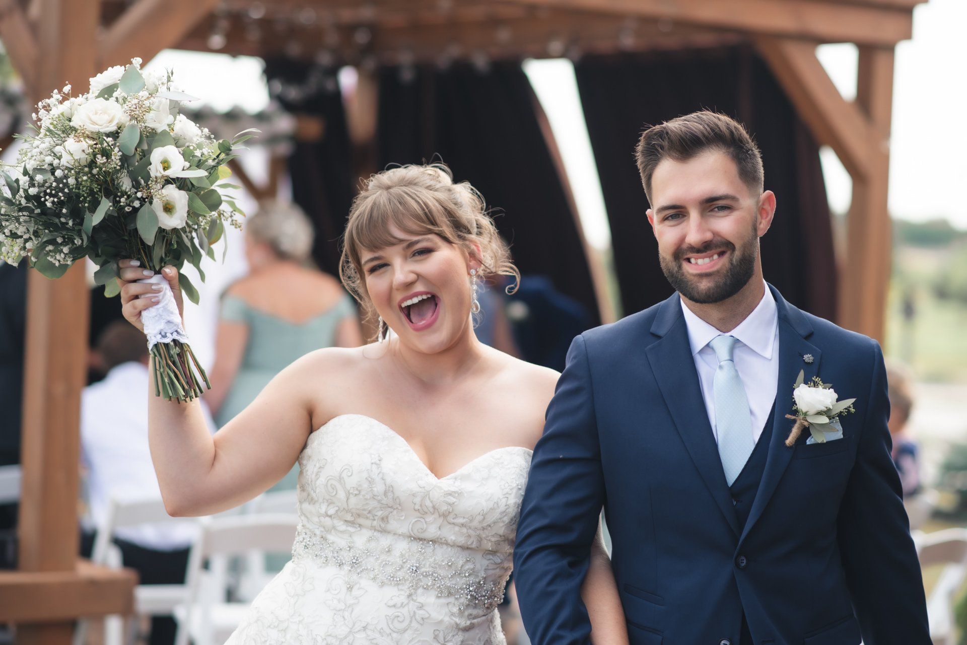 A bride and groom are walking down the aisle at their wedding.