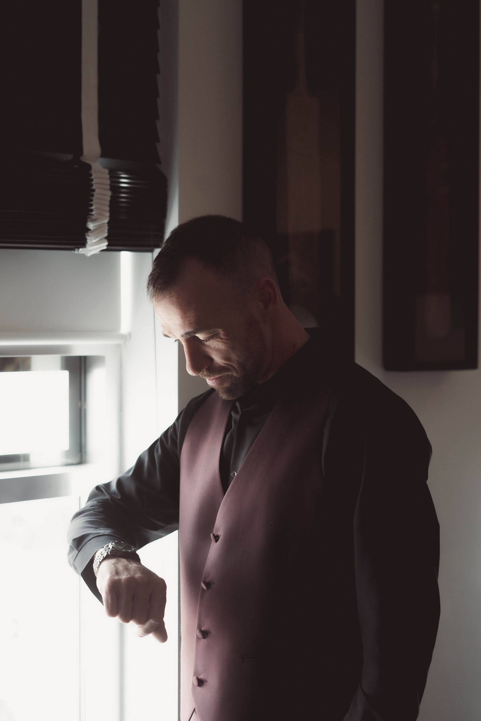 groom looking at watch by the window, Retro Suites Hotel, vintage wedding