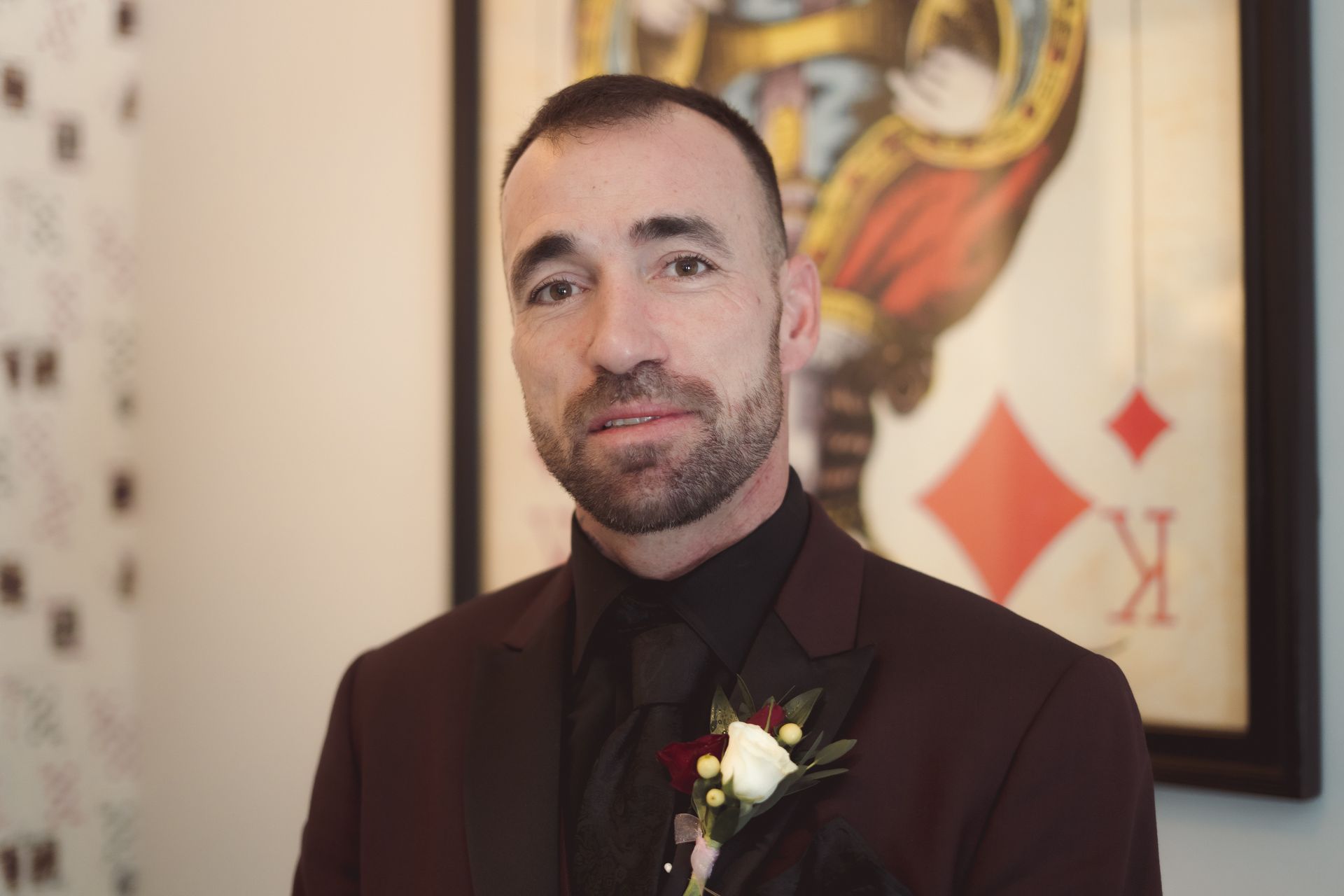Portrait of Groom in front of large playing card, Retro Suites Hotel, vintage wedding