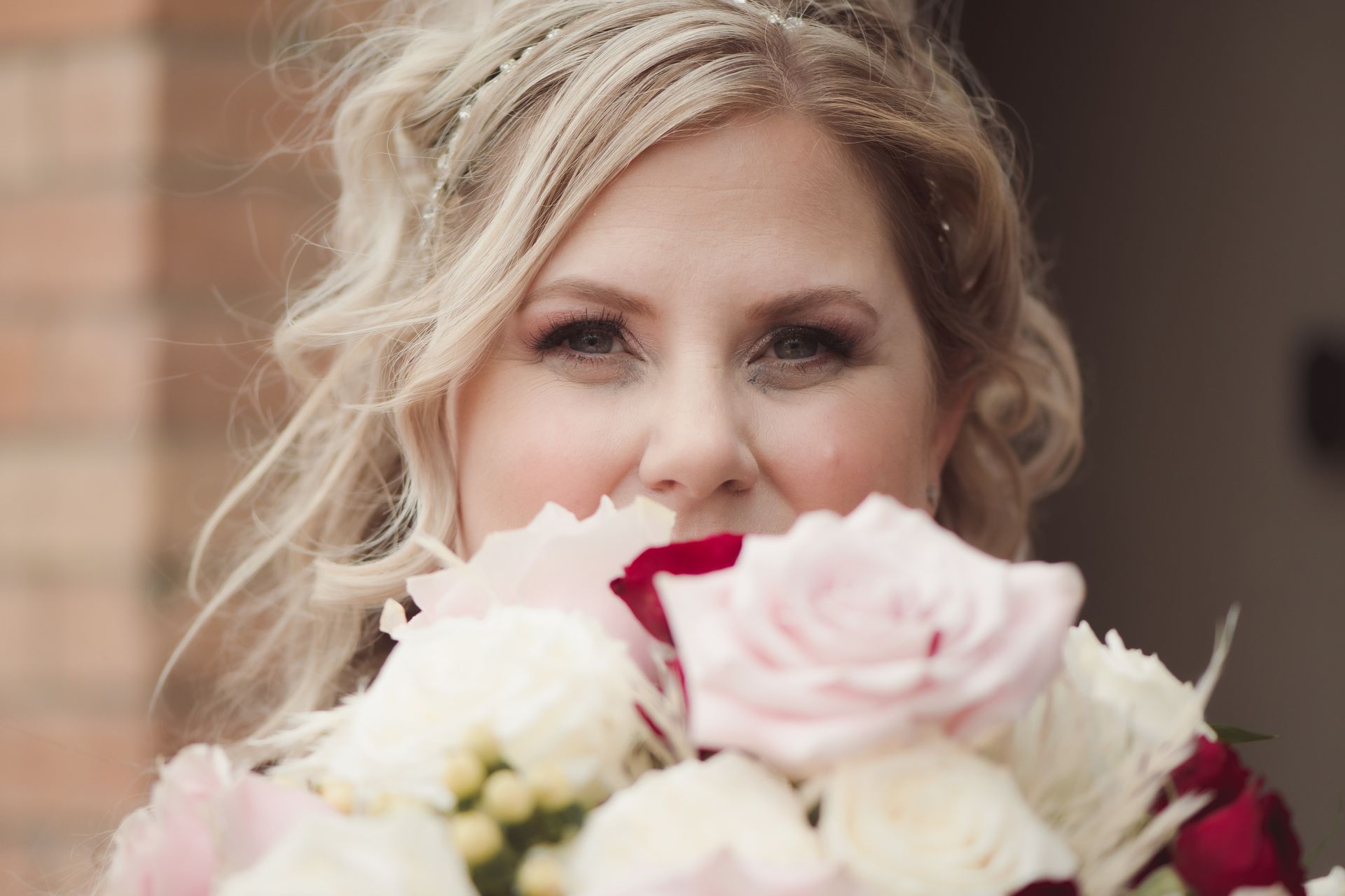 Portrait of bride behind flowers, gazing over top, Retro Suites Hotel, vintage wedding