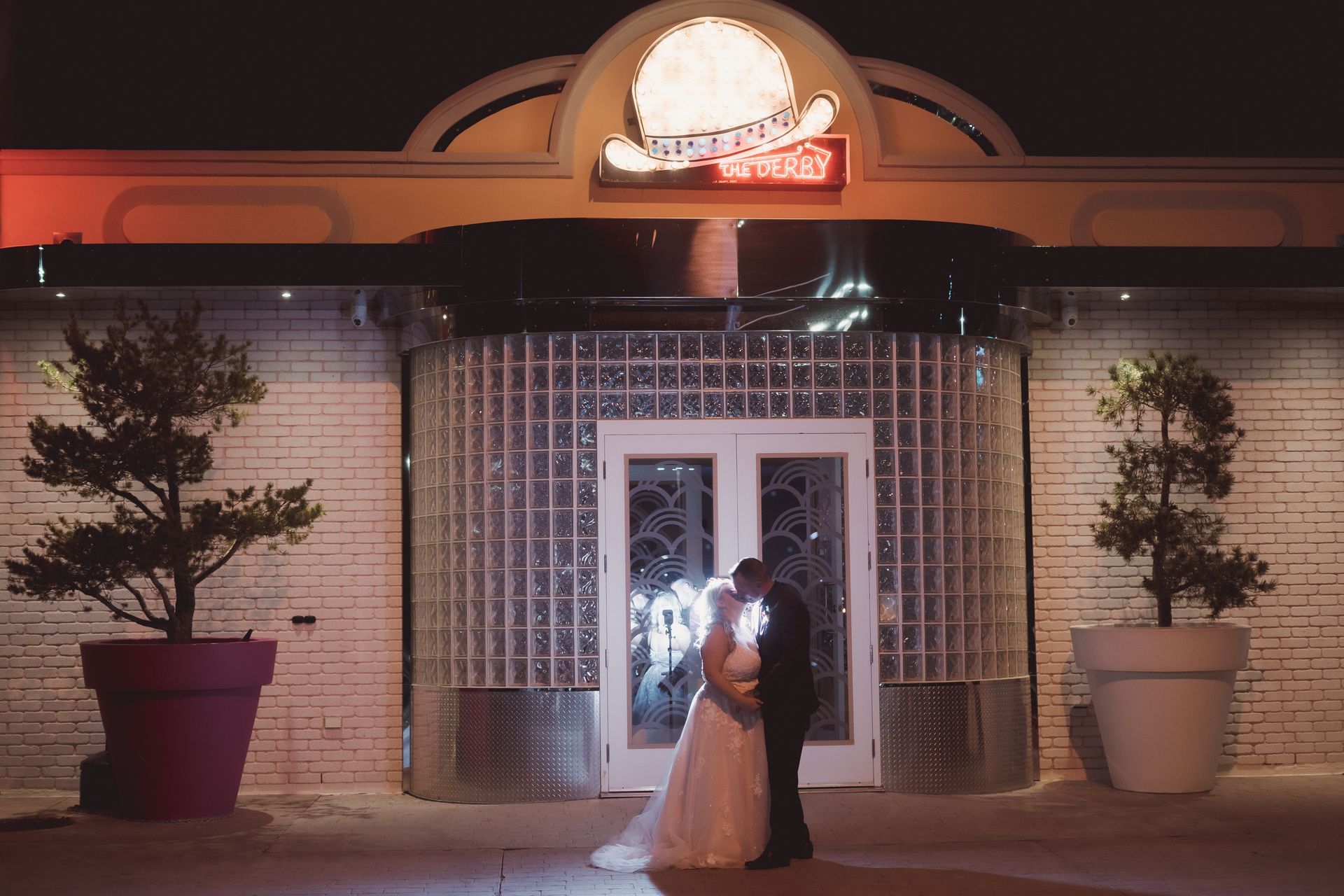 bride and groom night shot behind the retro suites under big hat, billboard with lights, Retro Suites Hotel, vintage wedding