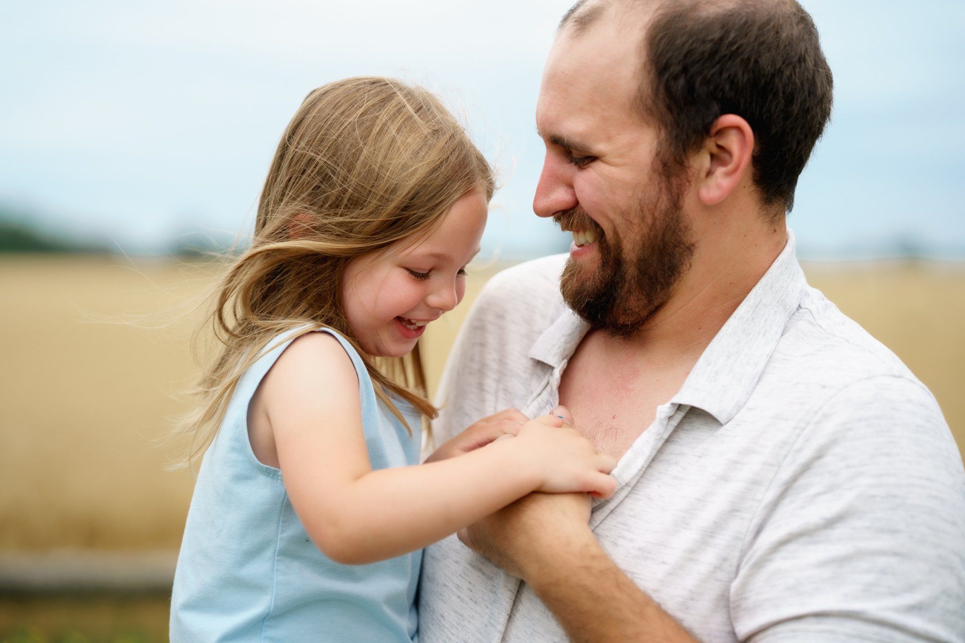 A man is holding a little girl in his arms.