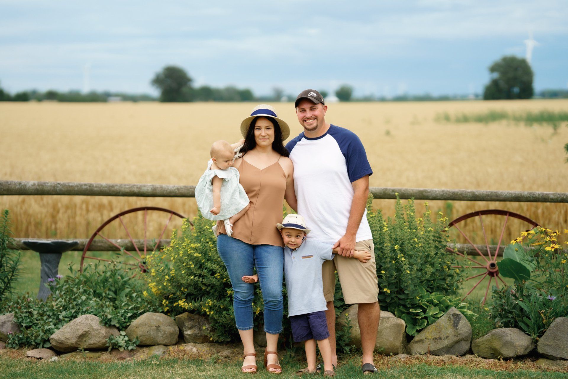 A family is posing for a picture in front of a field.