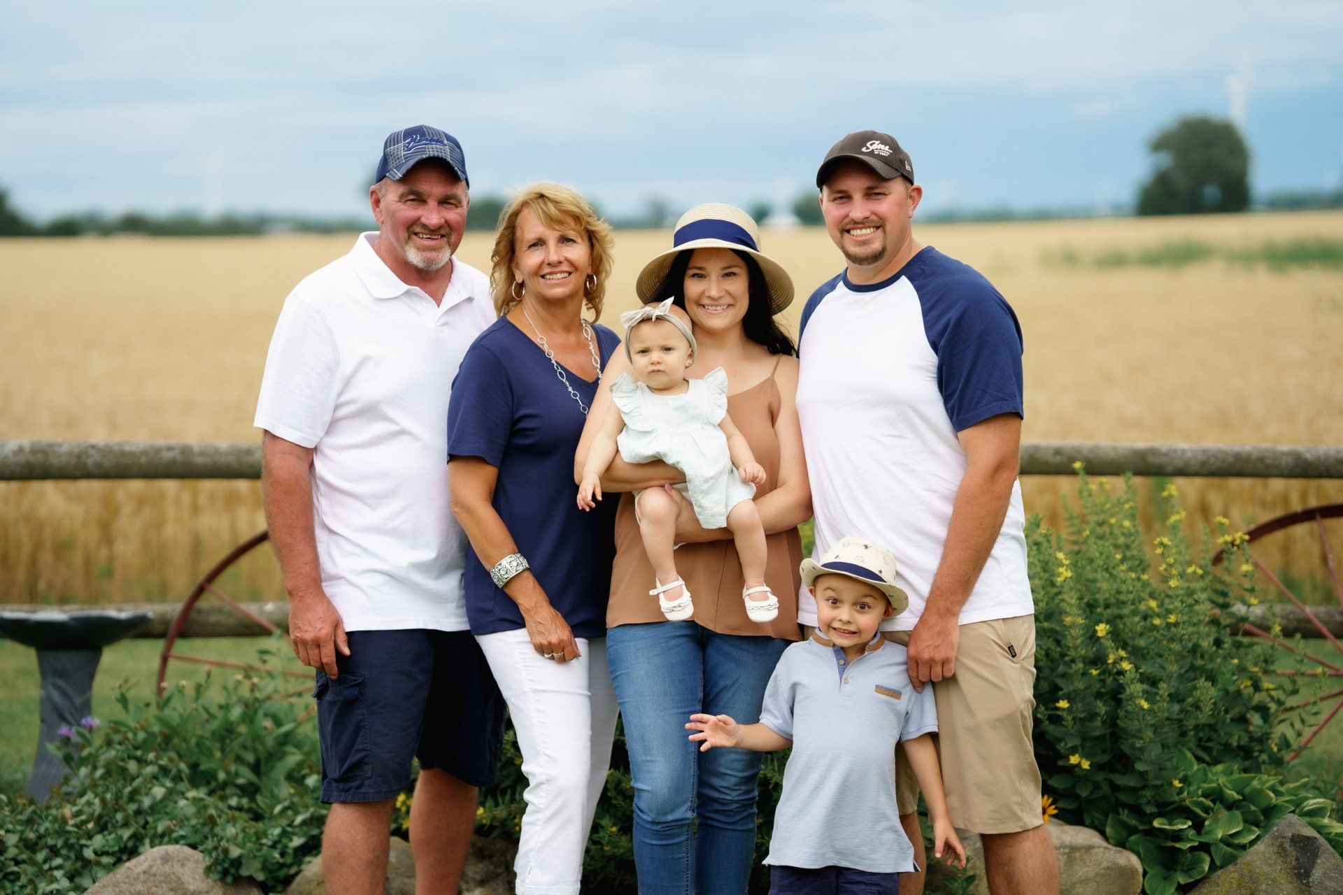 A family posing for a picture in front of a field.
