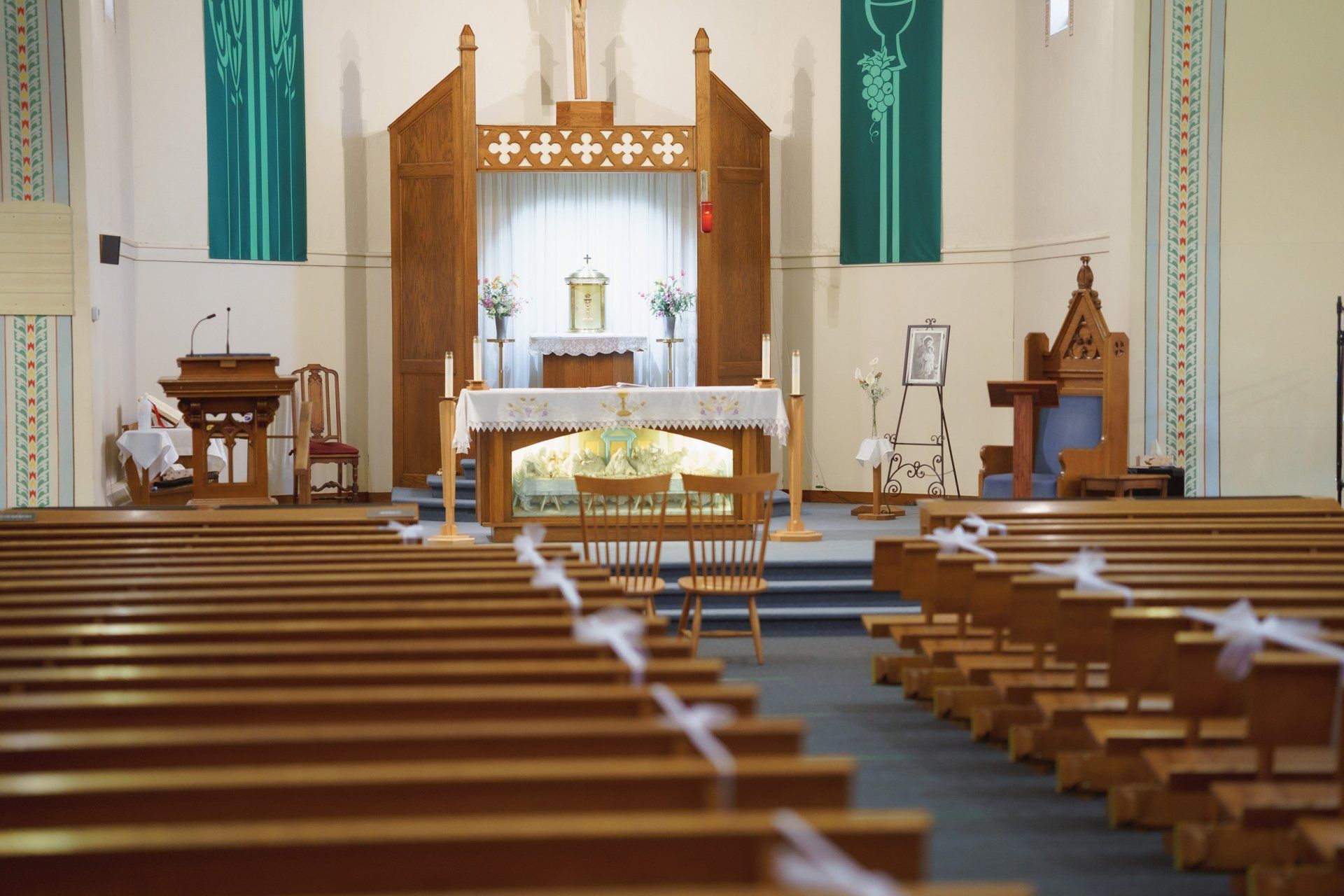 The inside of a church with rows of wooden benches and a altar.