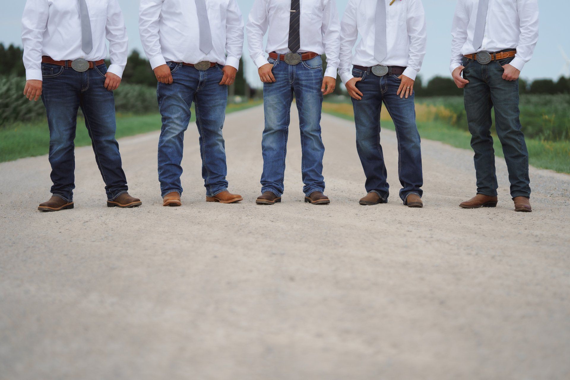 A group of men standing next to each other on a dirt road.