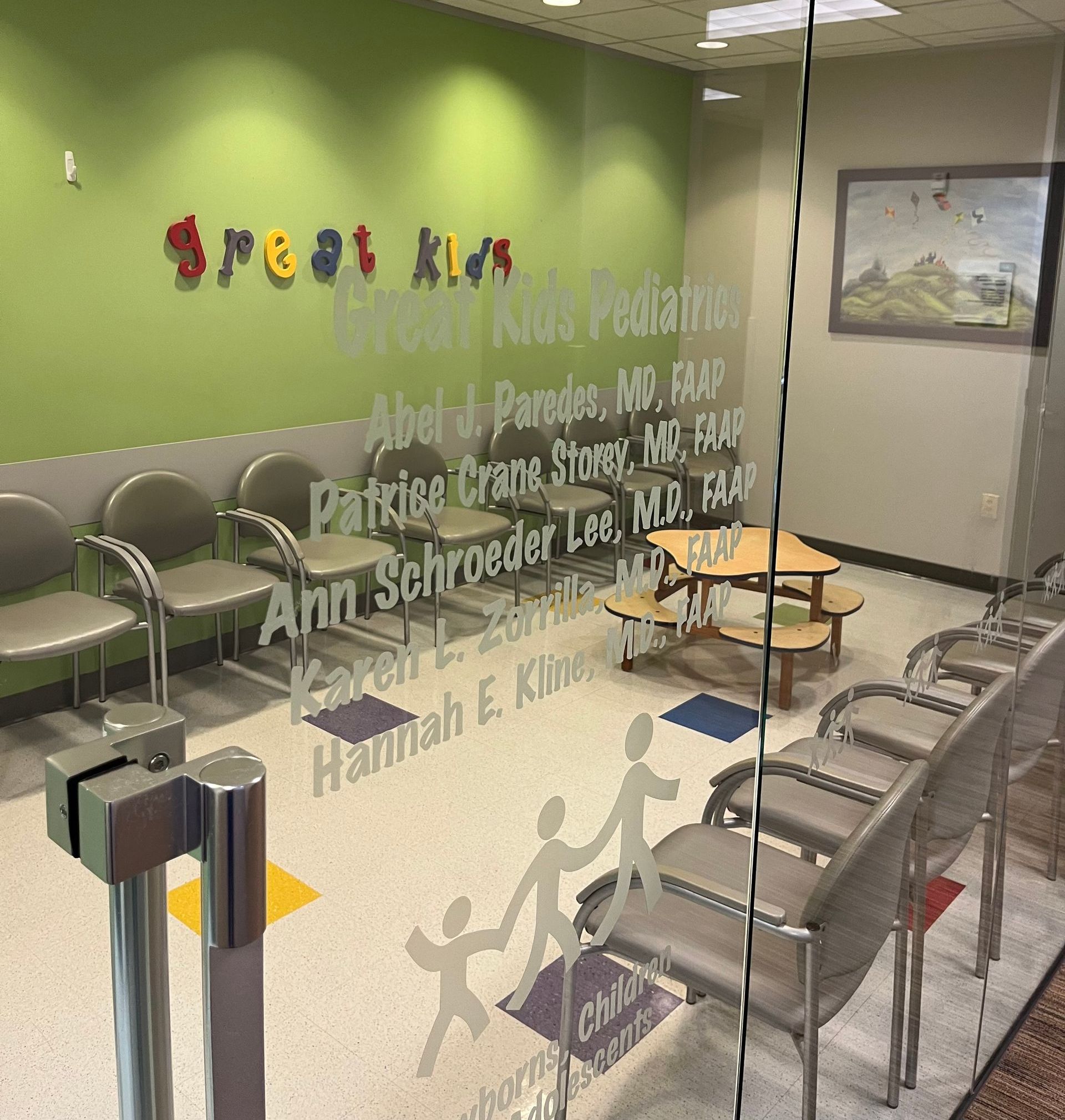 Inside of pediatric office of Great Kids Pediatrics in Houston, TX.  Office has green wall and an outside picture on wall.