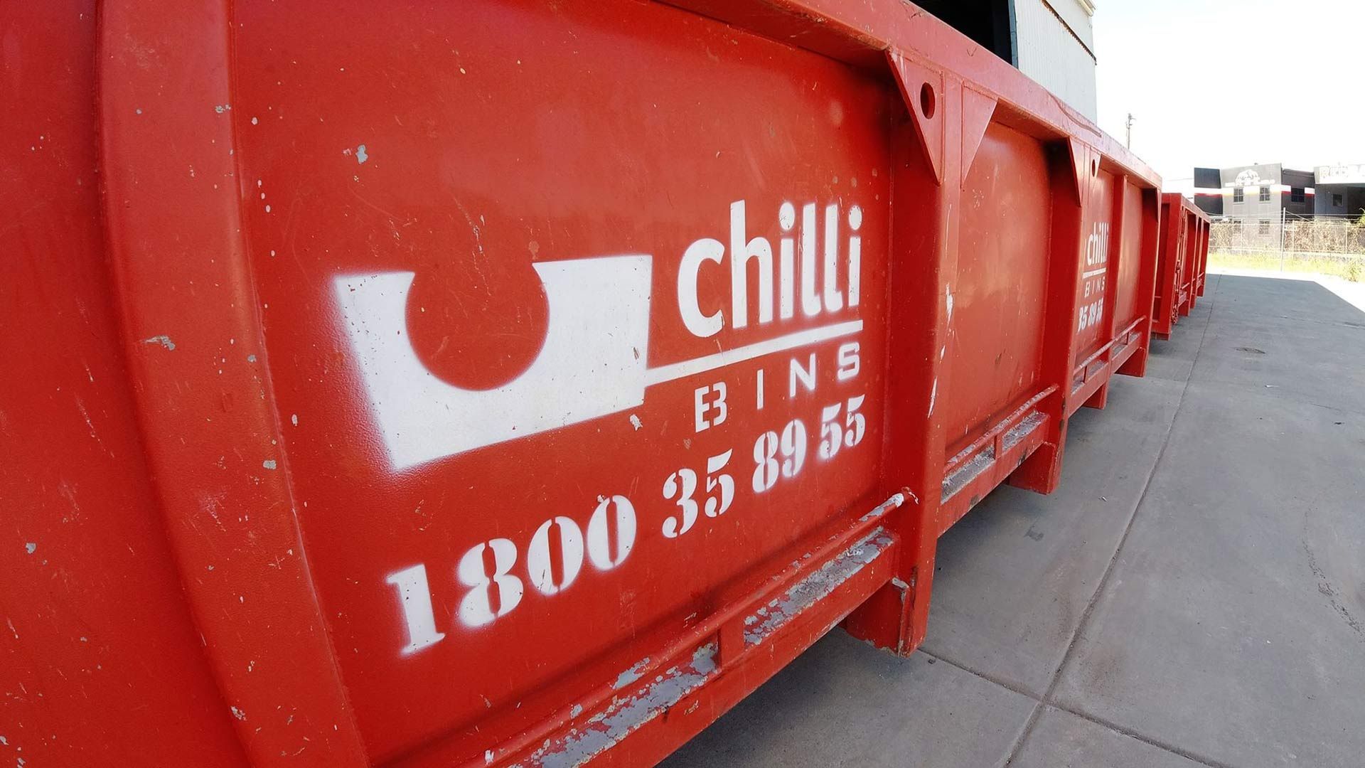 A Red Dumpster with The Word Chilli Written on It — Chilli Bins Skip Bins in Glenview, QLD