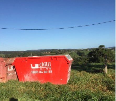 Red Skip Bin On Section Of Land— Chilli Bins Skip Bins in Noosa, QLD