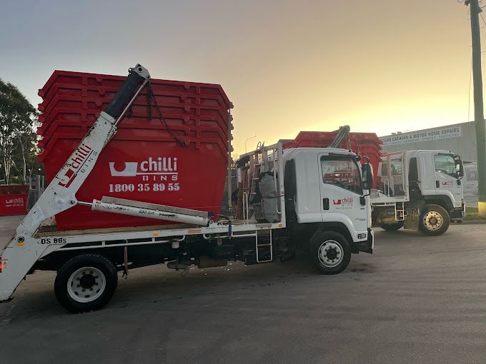 Two Red Dumpsters with Chili Written on Them Are Stacked on Top of Each Other — Chilli Bins Skip Bins in Caloundra, QLD