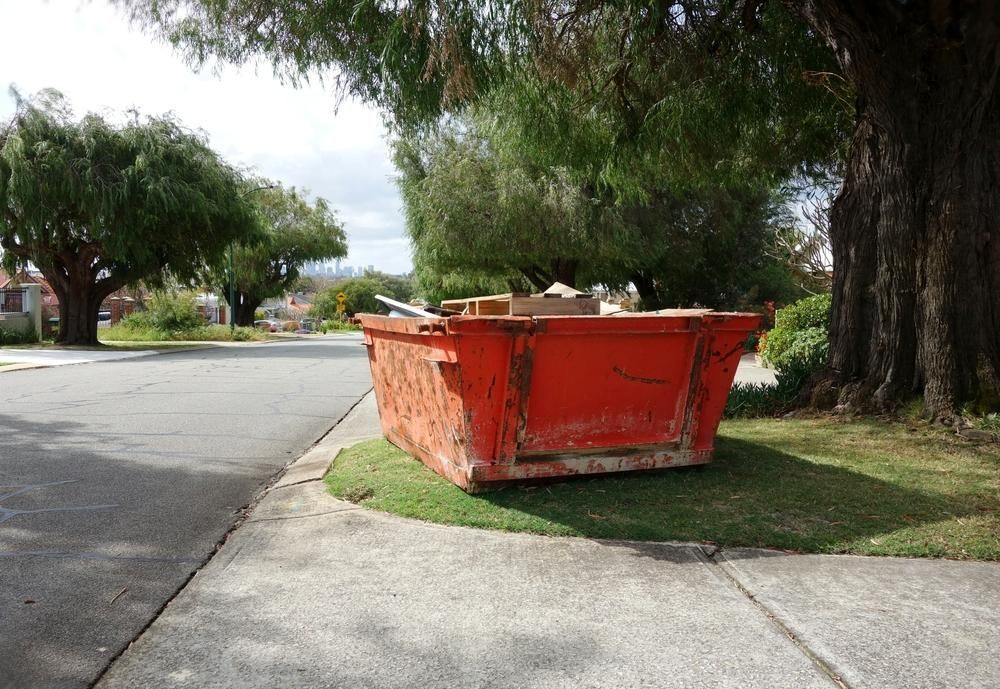 A Red Dumpster Is Sitting on The Side of The Road — Chilli Bins Skip Bins in Caloundra, QLD