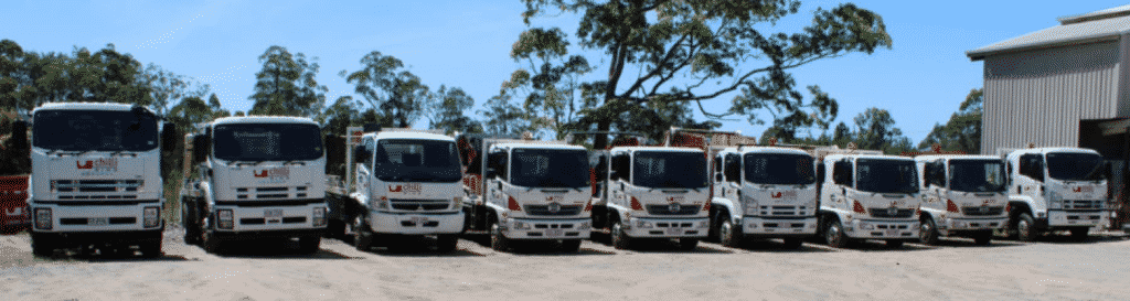 A Row of Trucks Are Parked in A Parking Lot — Chilli Bins Skip Bins in Glenview, QLD