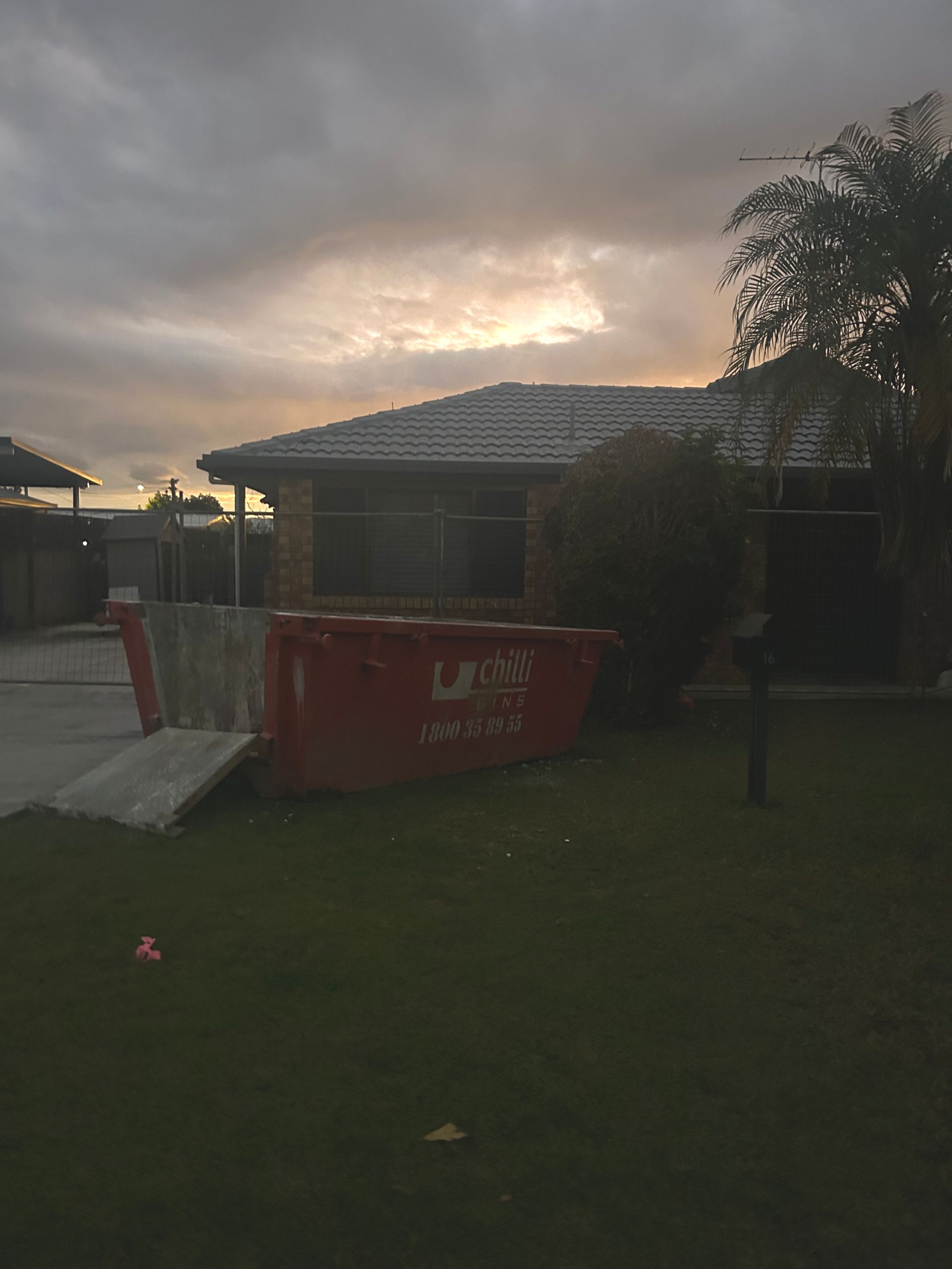 A White Car Is Parked in Front of A House — Chilli Bins Skip Bins in Caboolture, QLD