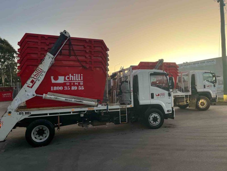 Red Chilli Bins On A Truck With Sunset Background — Chilli Bins Skip Bins in Glenview, QLD