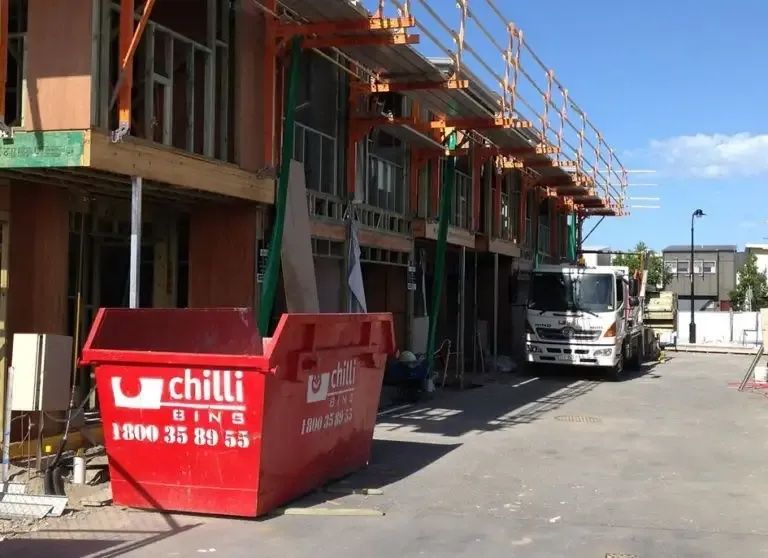 A Red Dumpster Sits in Front of A House Under Construction — Chilli Bins Skip Bins in Glenview, QLD