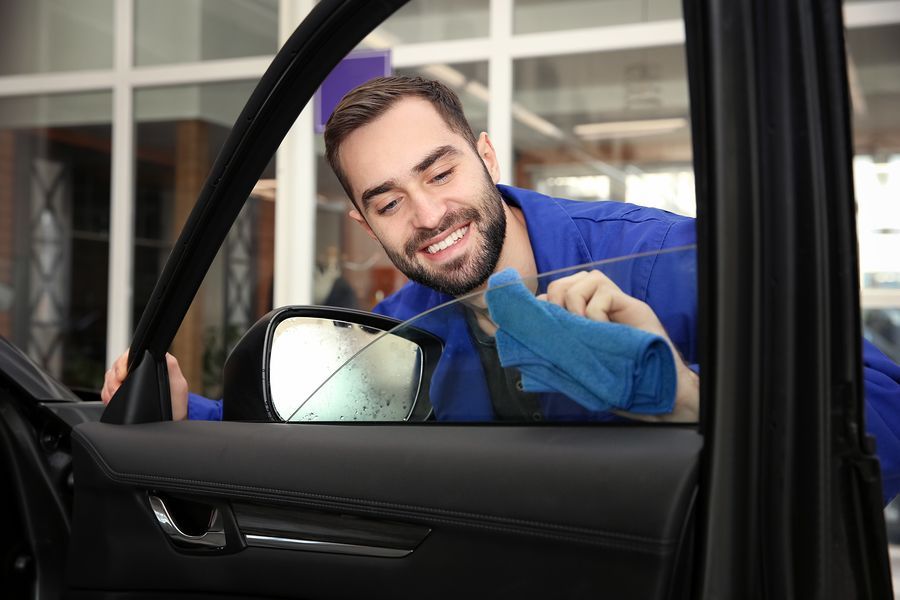 a man in a blue shirt is looking at his reflection in the side mirror