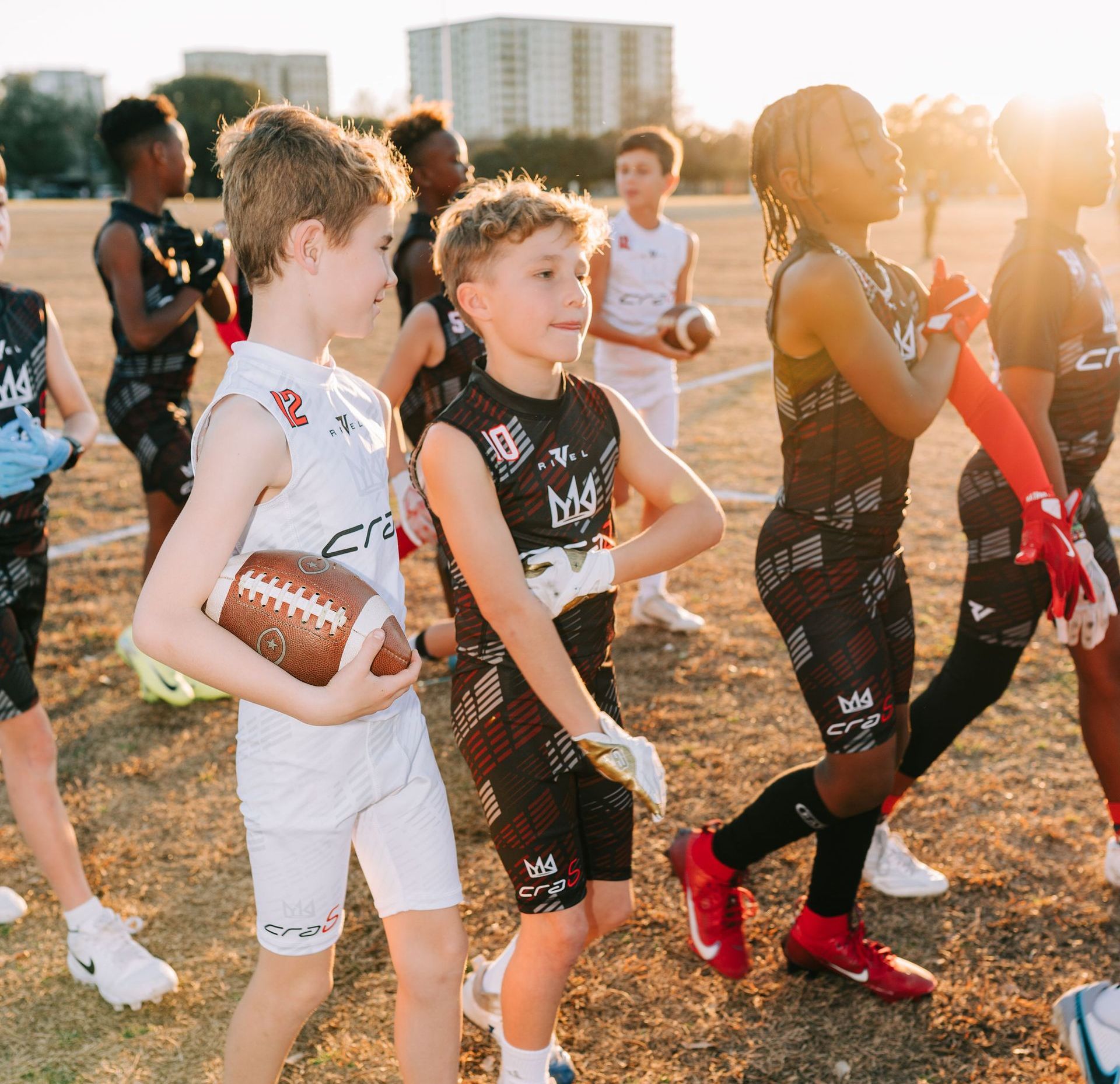 An empty football field with a stadium in the background.