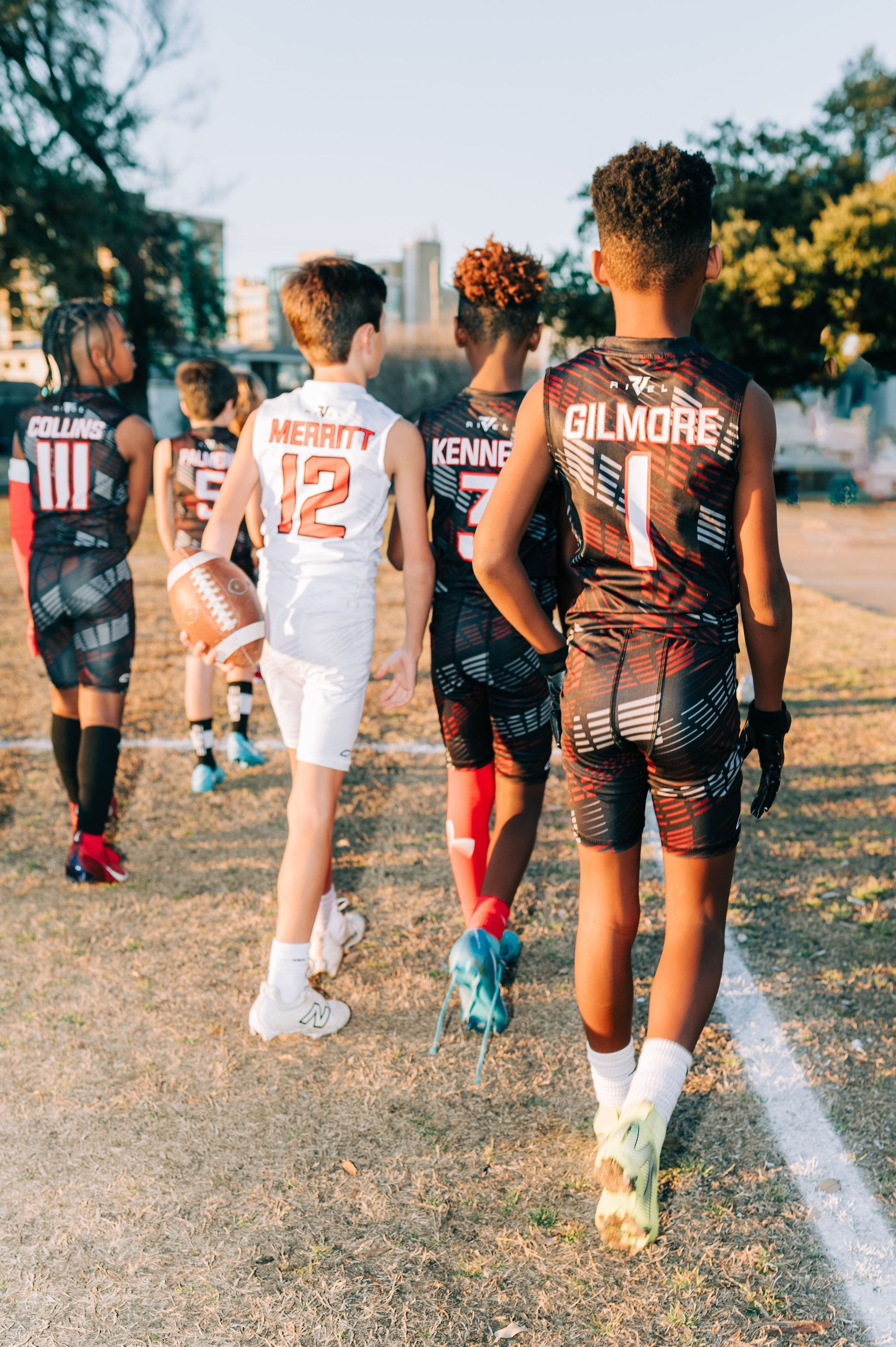 A group of football players are lined up in a huddle on a field.