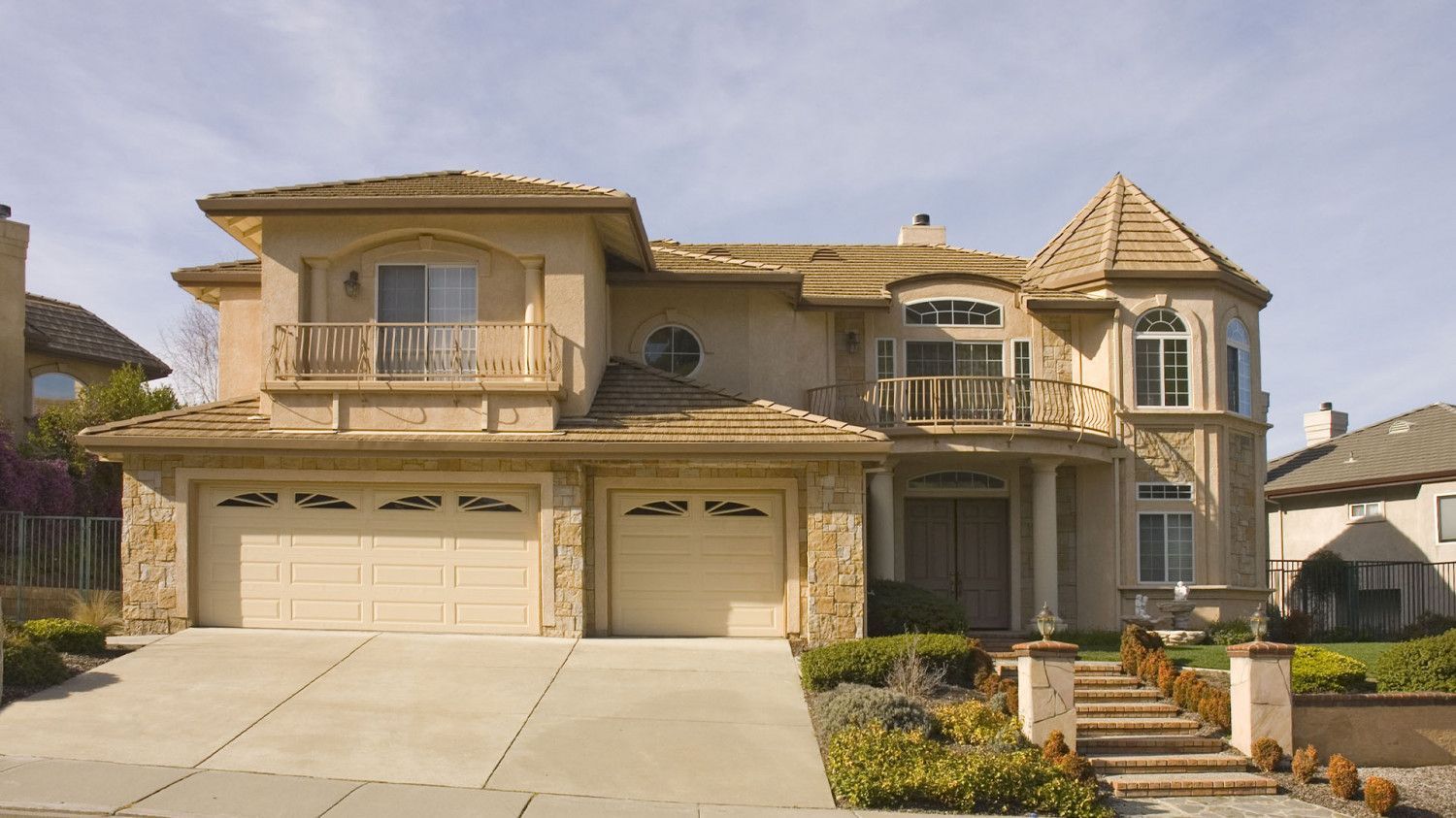 A large house with two garage doors and stairs leading up to it