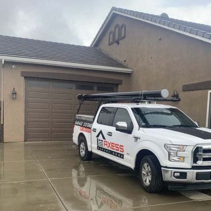 A white truck is parked in front of a house.