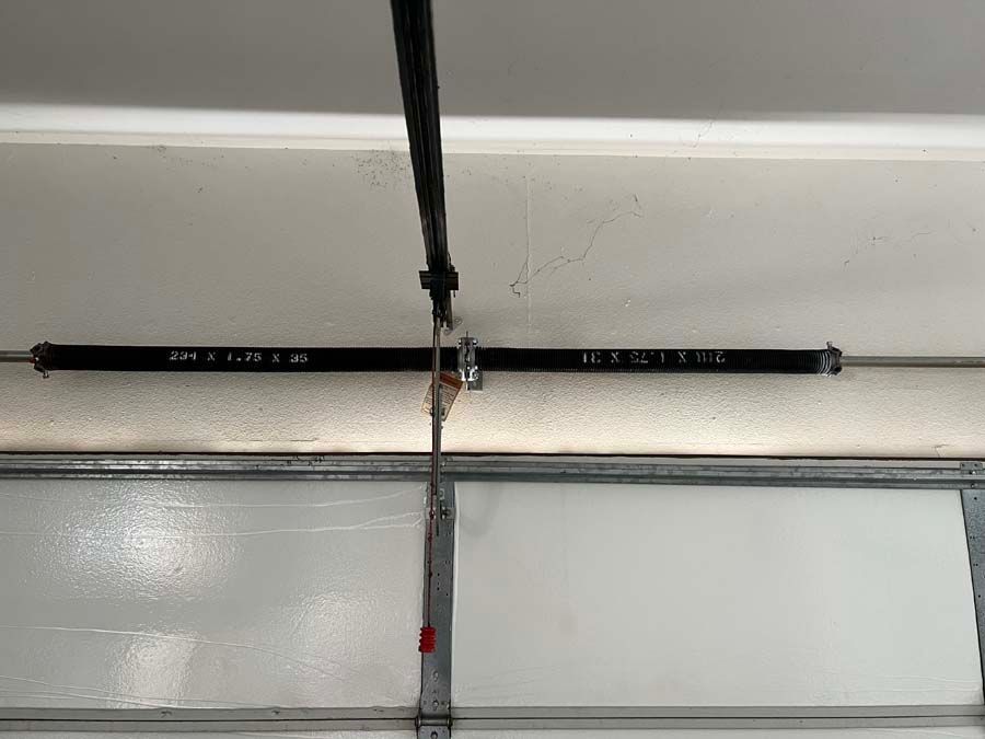 A close up of a garage door spring in a garage.