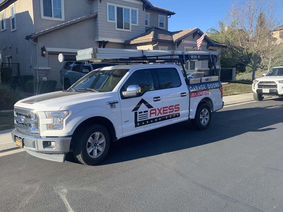 A white truck is parked in front of a house.