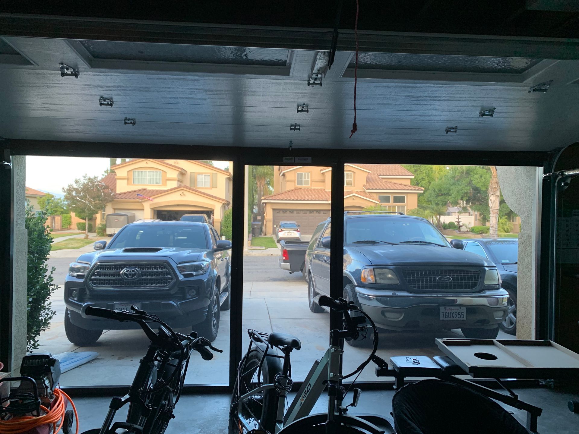 A truck is parked in a garage next to a pool table.