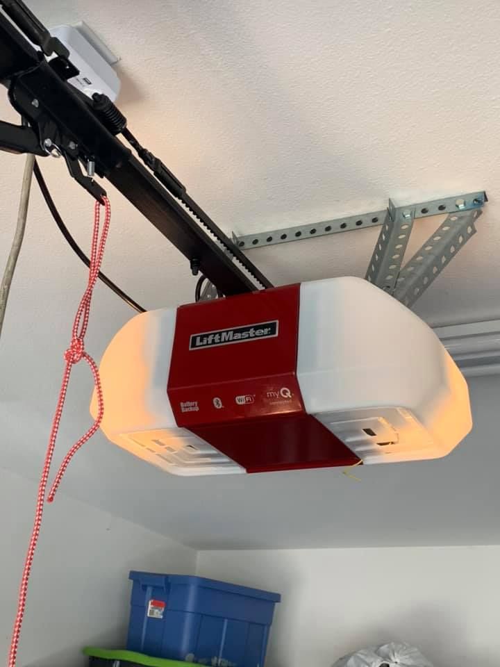 A red liftmaster garage door opener is hanging from the ceiling