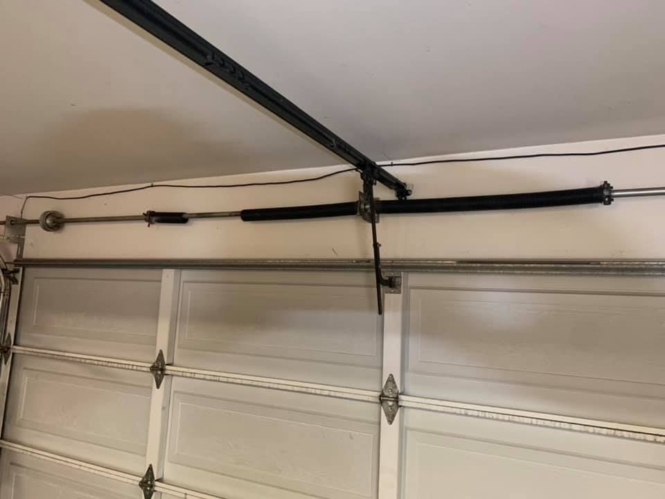 A garage door with a spring hanging from the ceiling.